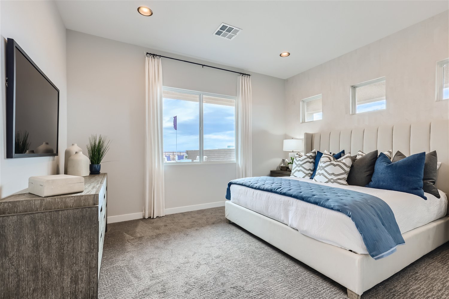 A bedroom with a large window.