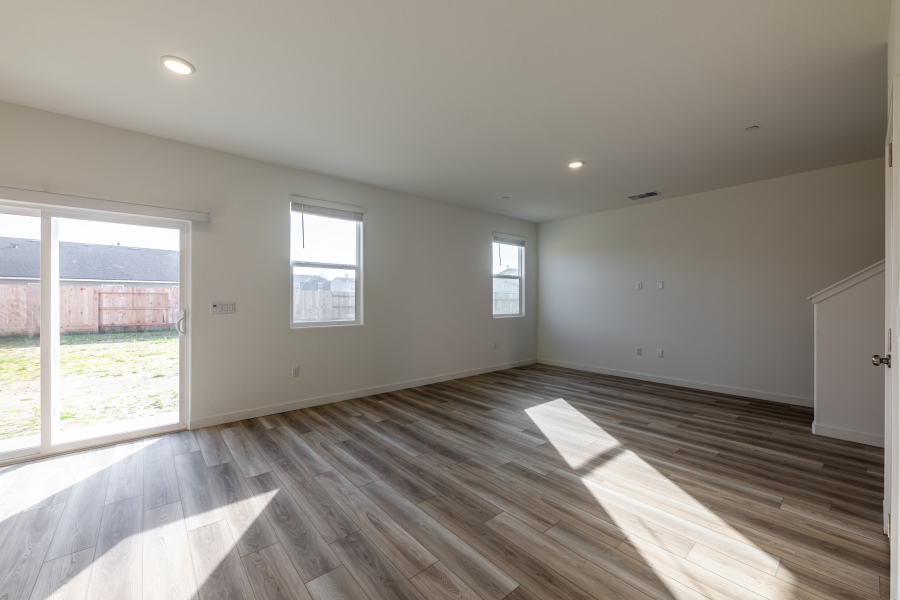 A room with a wood floor and windows.