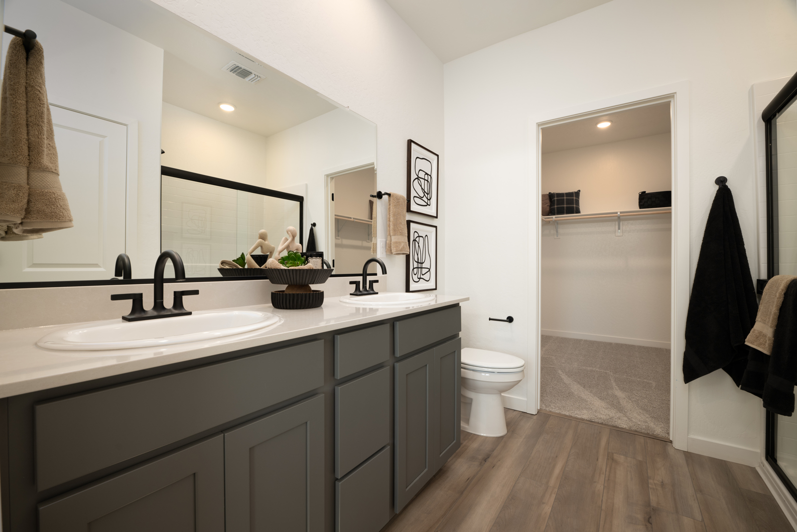 A bathroom with a sink toilet and mirror.