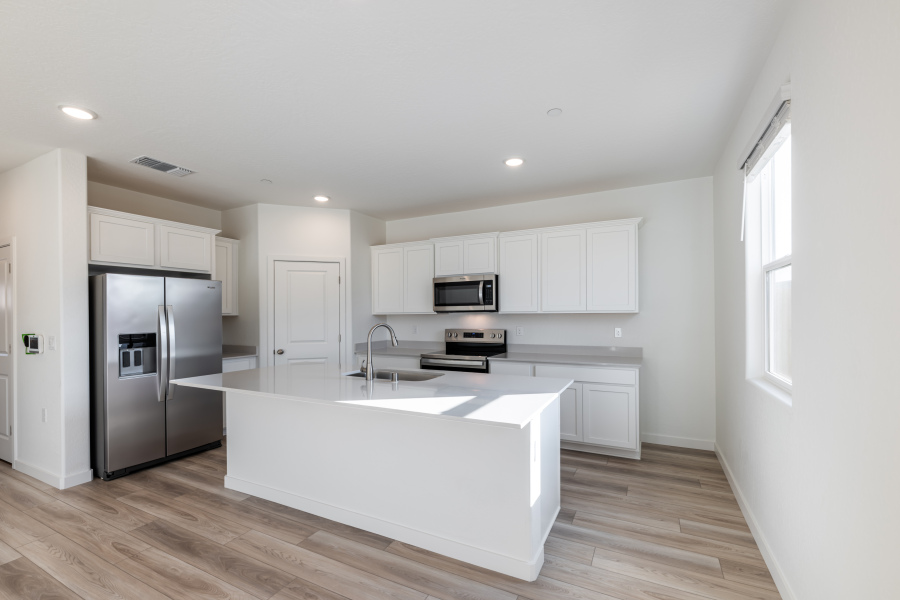 A kitchen with white cabinets.