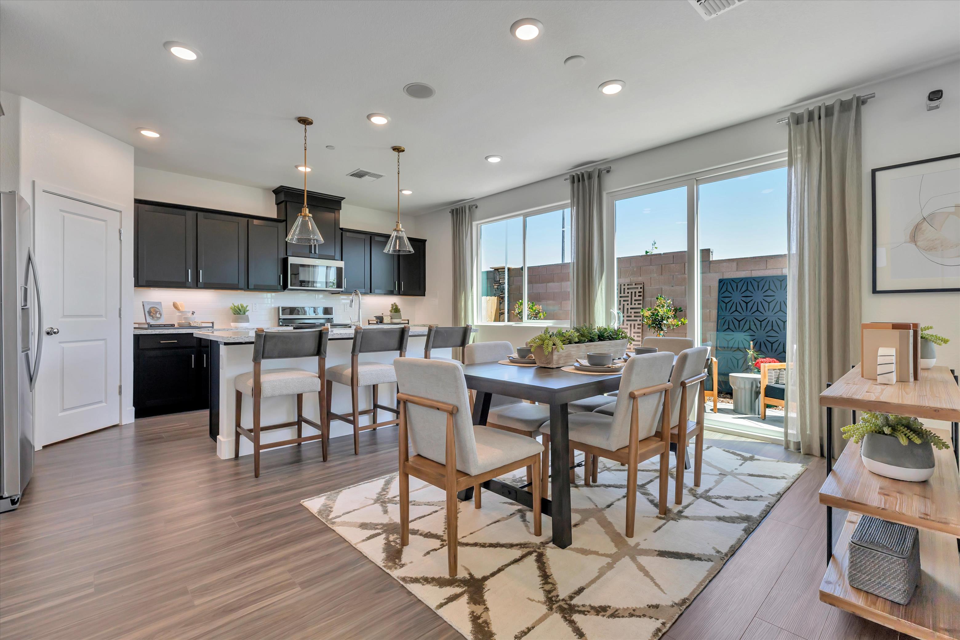 A kitchen with a dining table and chairs.