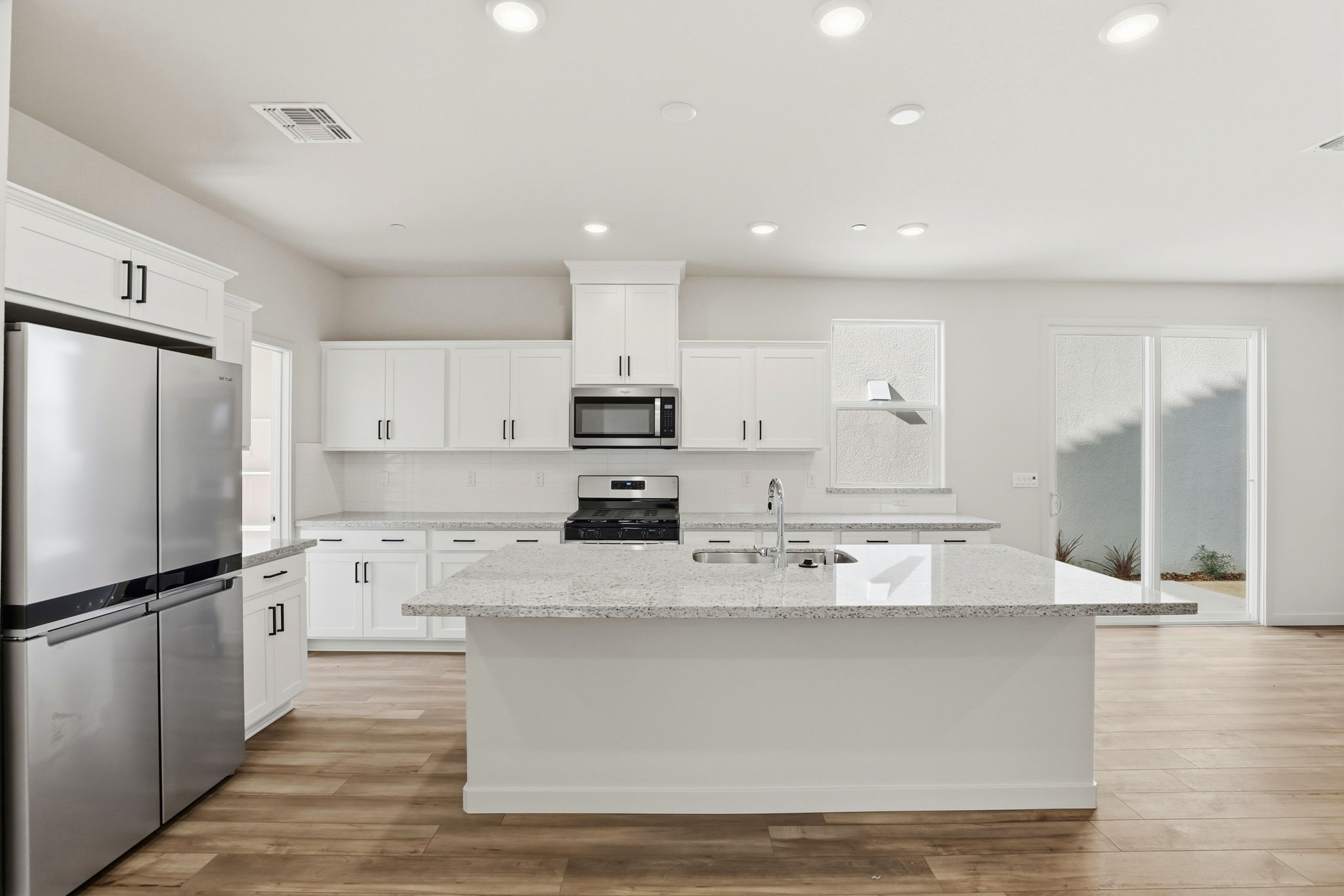 A kitchen with white cabinets.