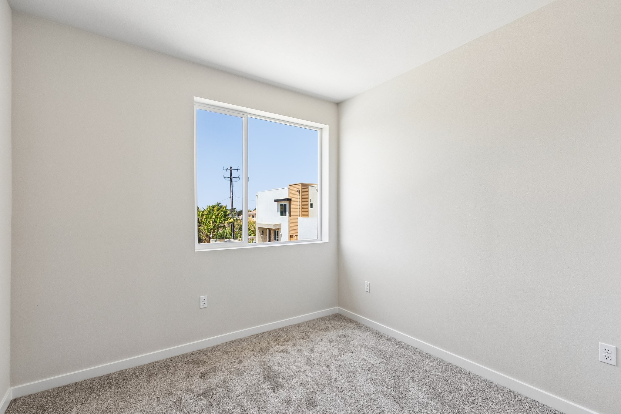 A room with a window and a rug.