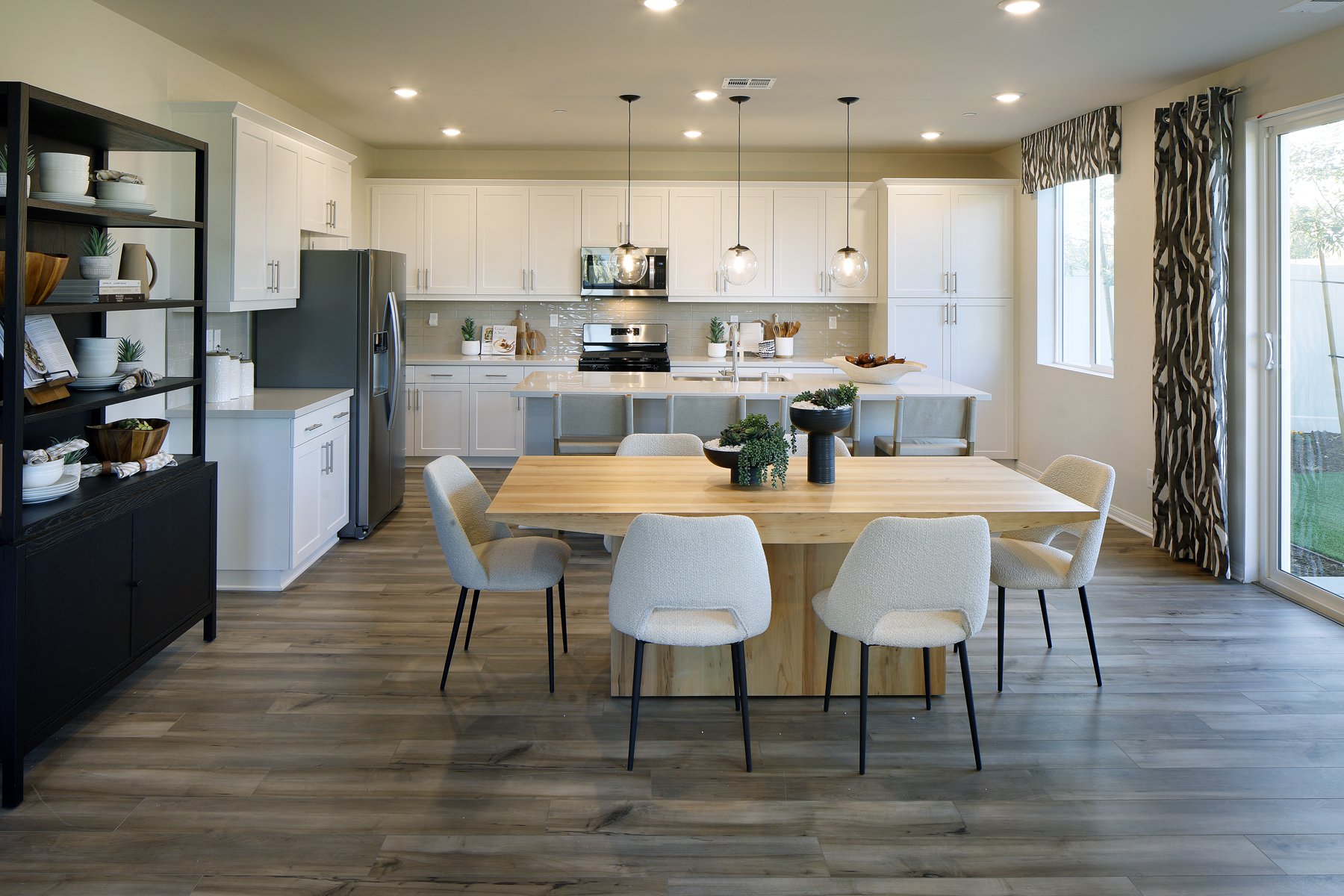A kitchen with a dining table and chairs.