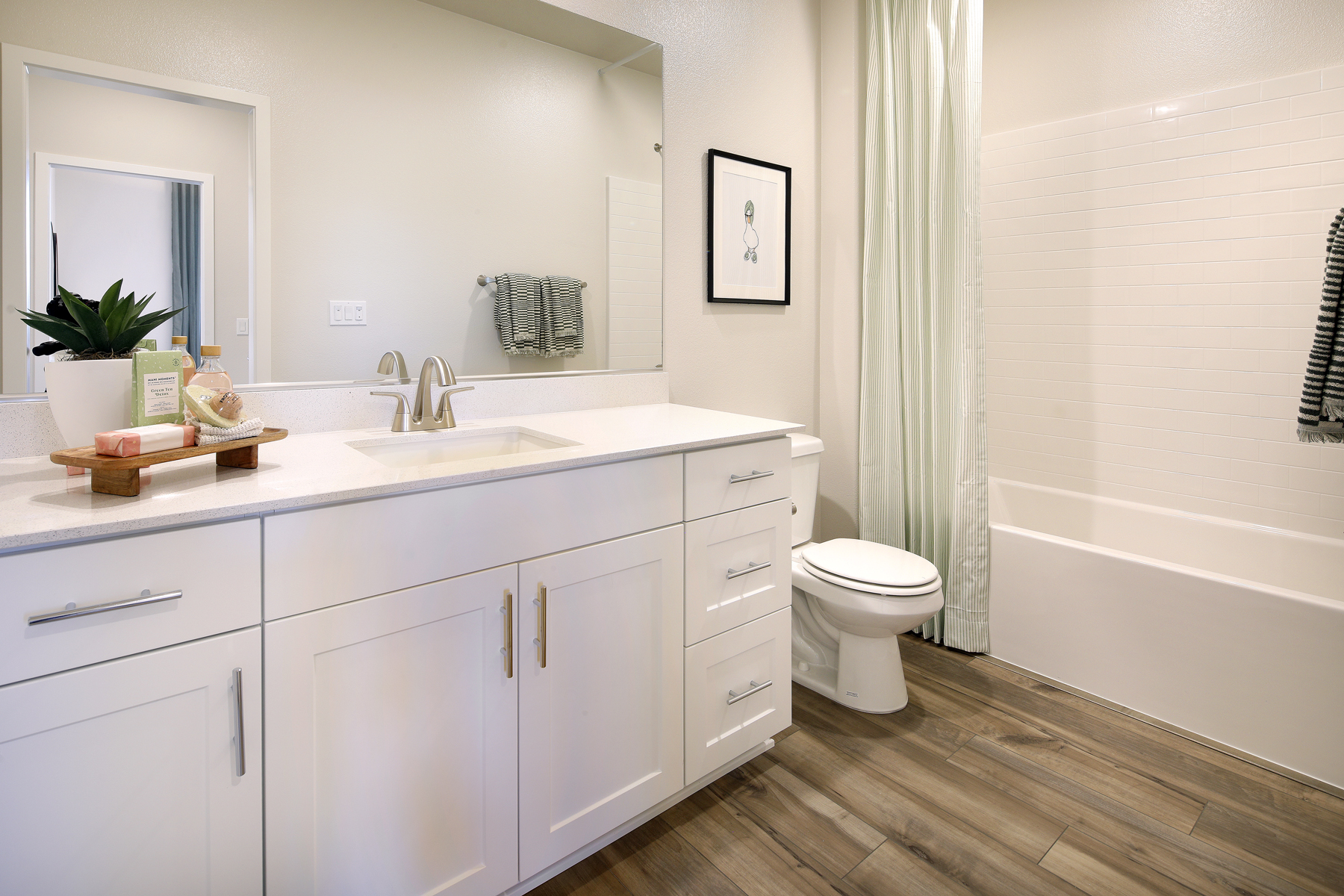 A bathroom with white cabinets.