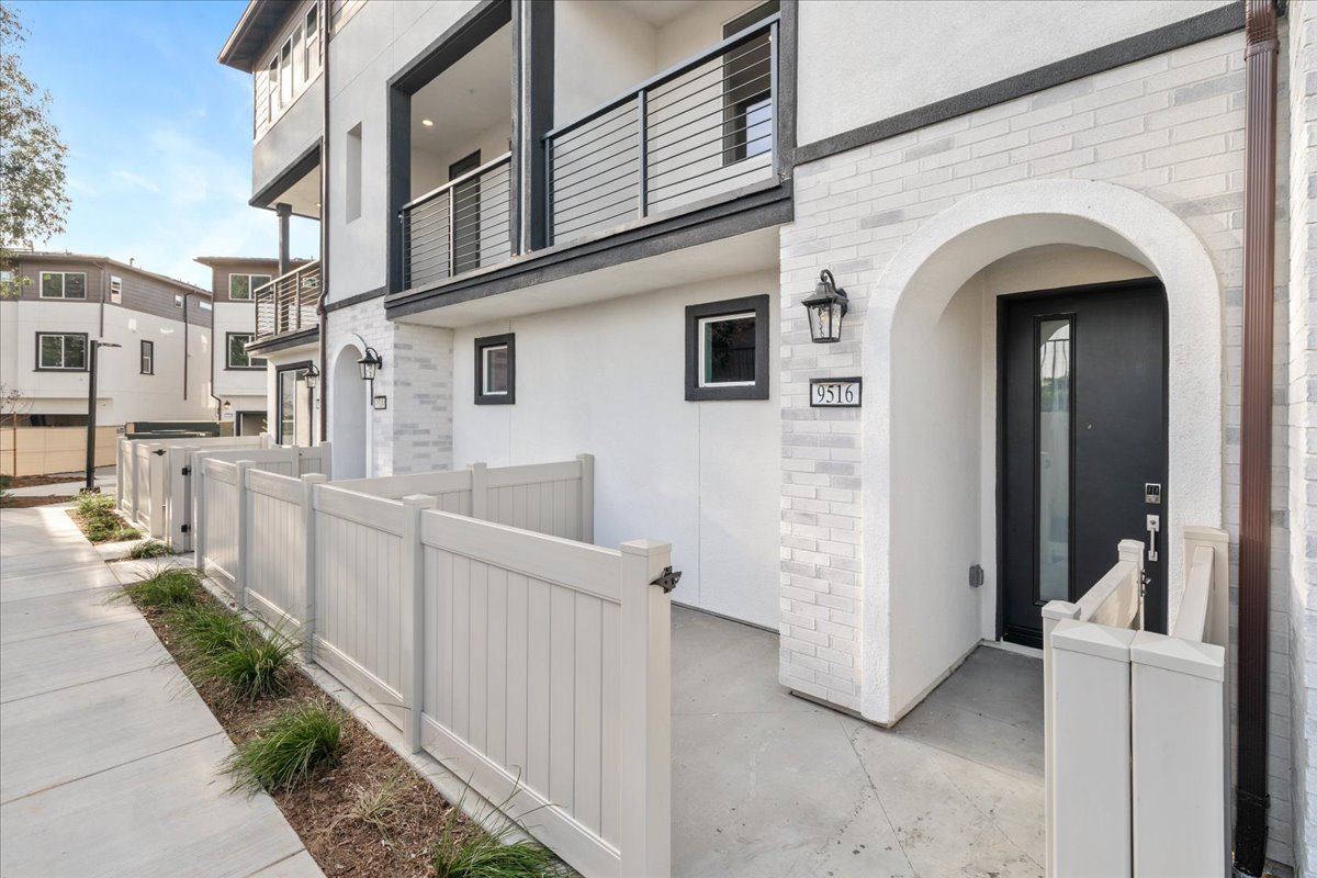 A white building with a white fence.