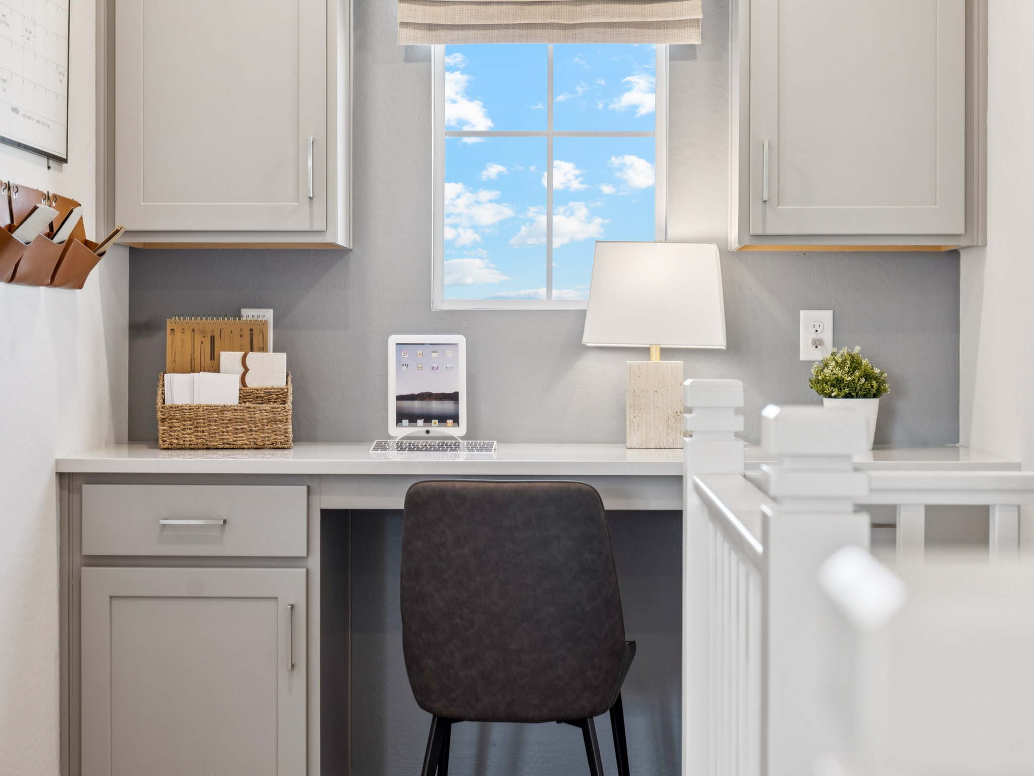 A white kitchen with a black chair.
