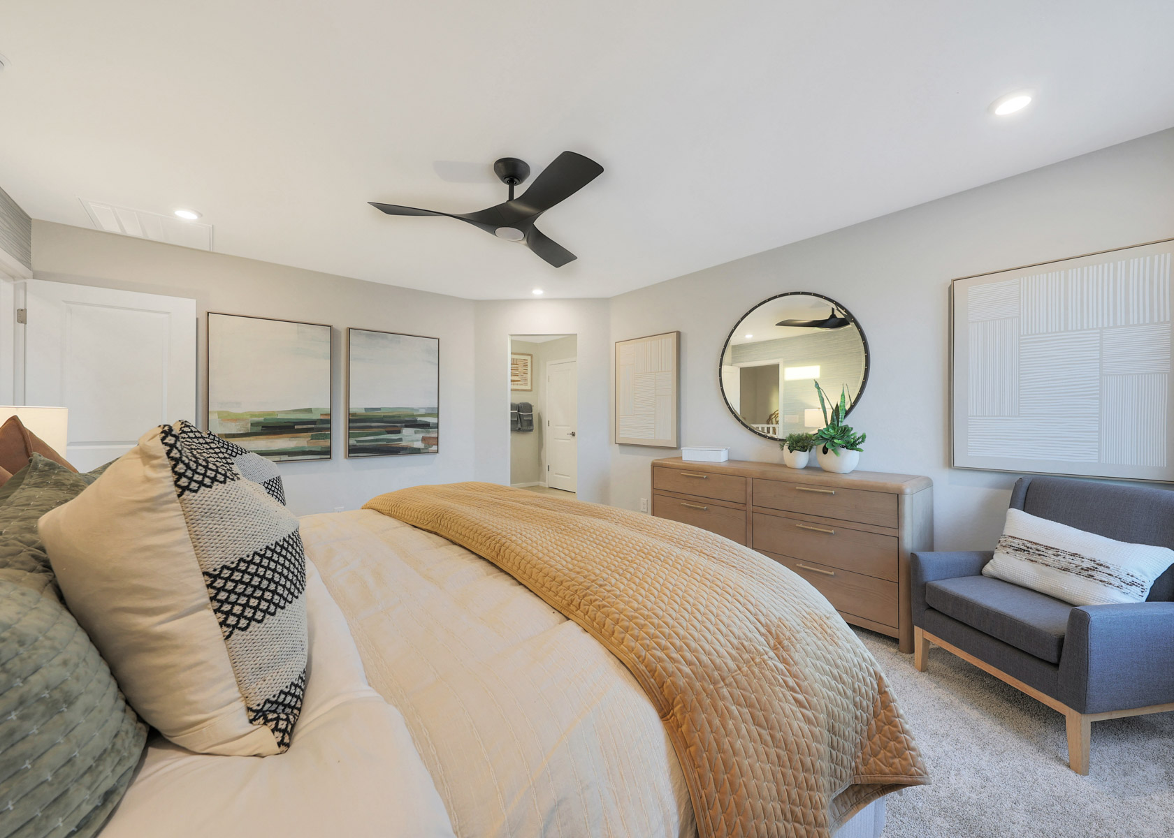 A bedroom with a bed and a fan.