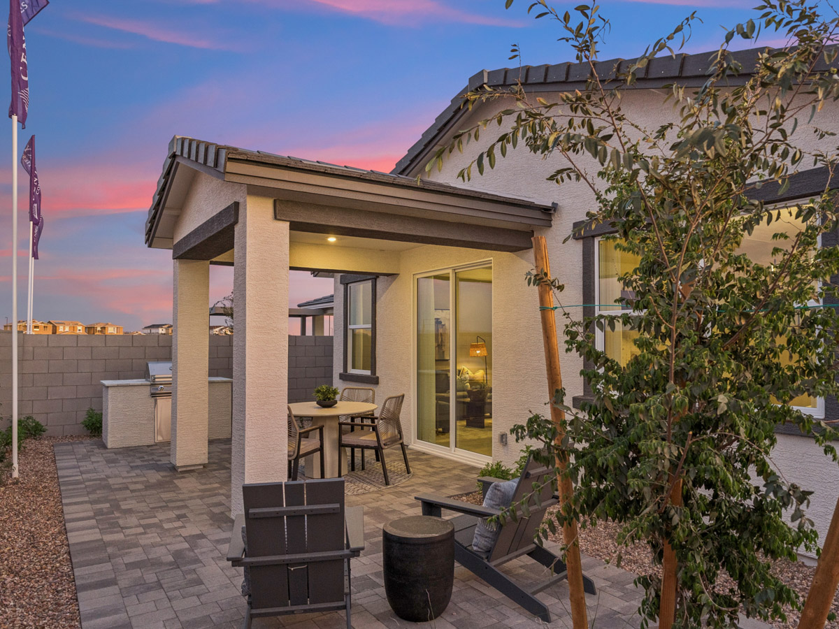 A house with a patio and a tree in the front.
