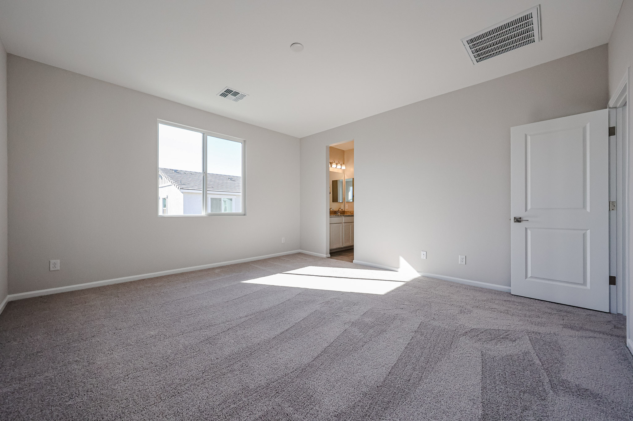 A large empty room with a carpet.