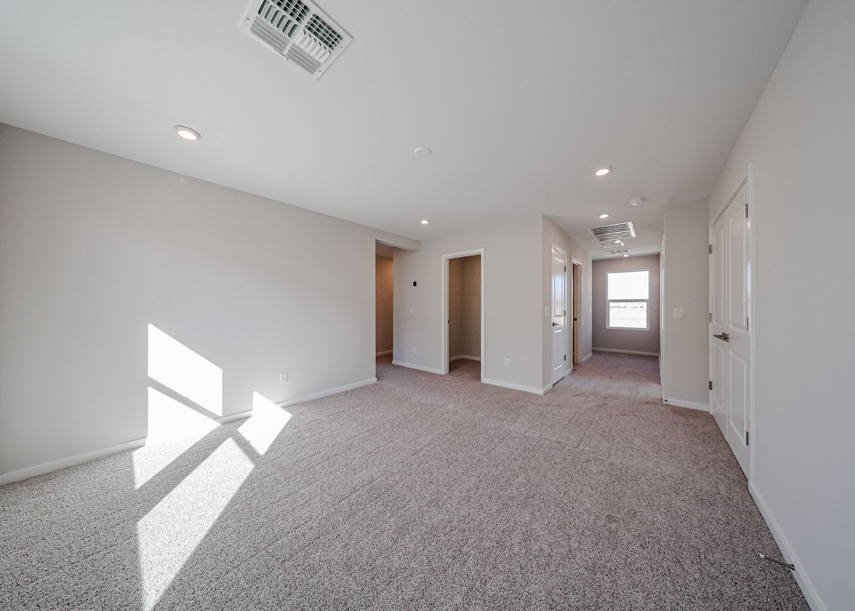 A long hallway with white doors.
