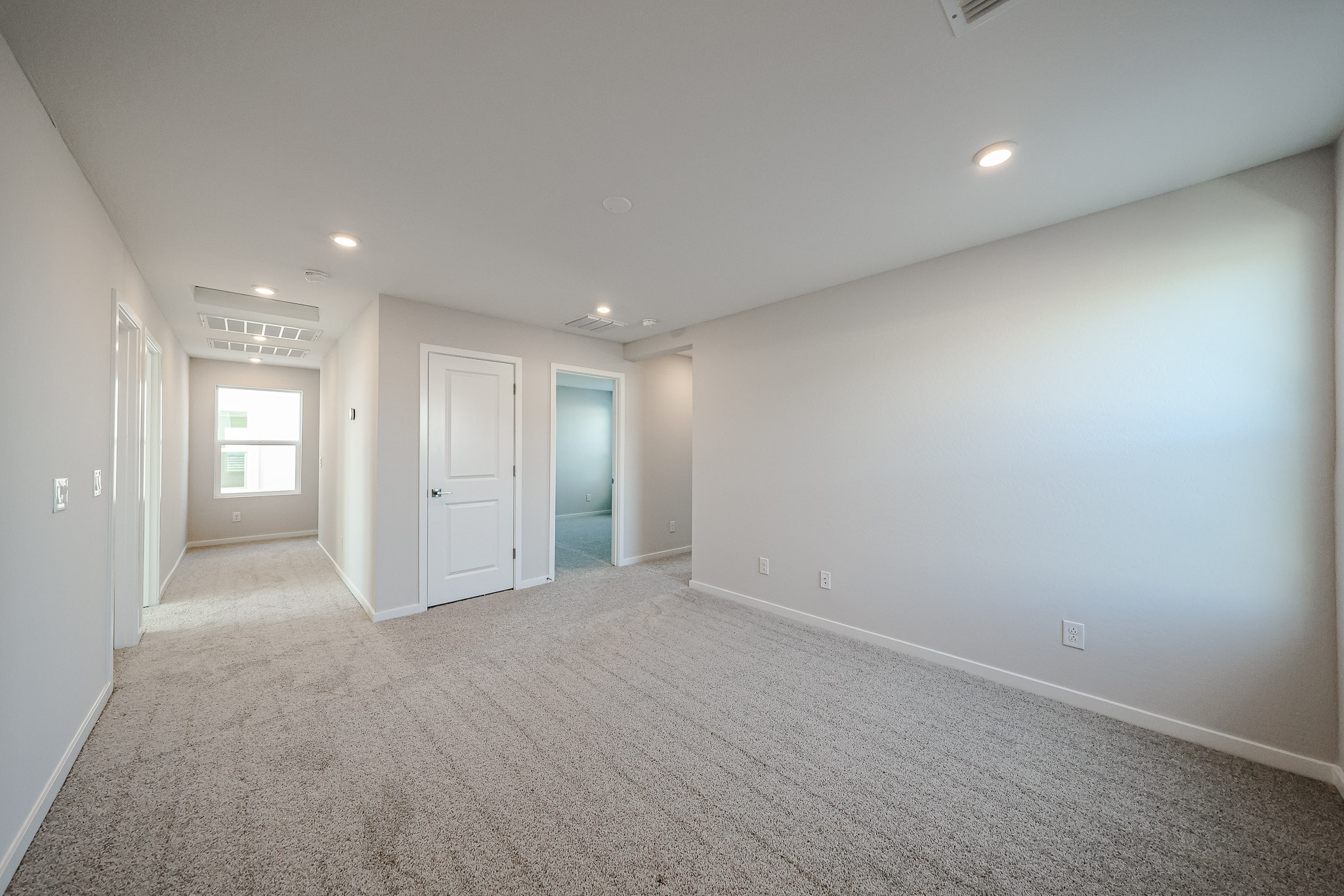 A long hallway with white doors.
