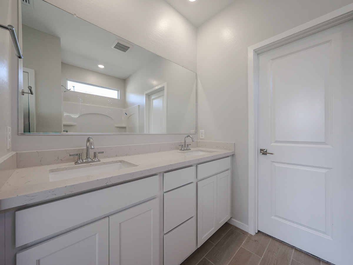 A bathroom with white cabinets.