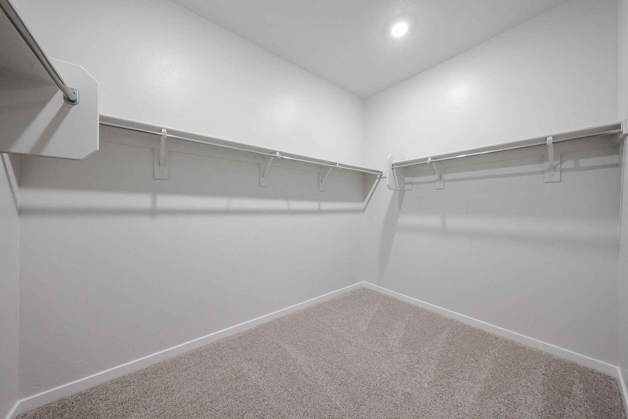 A white hallway with a metal railing.