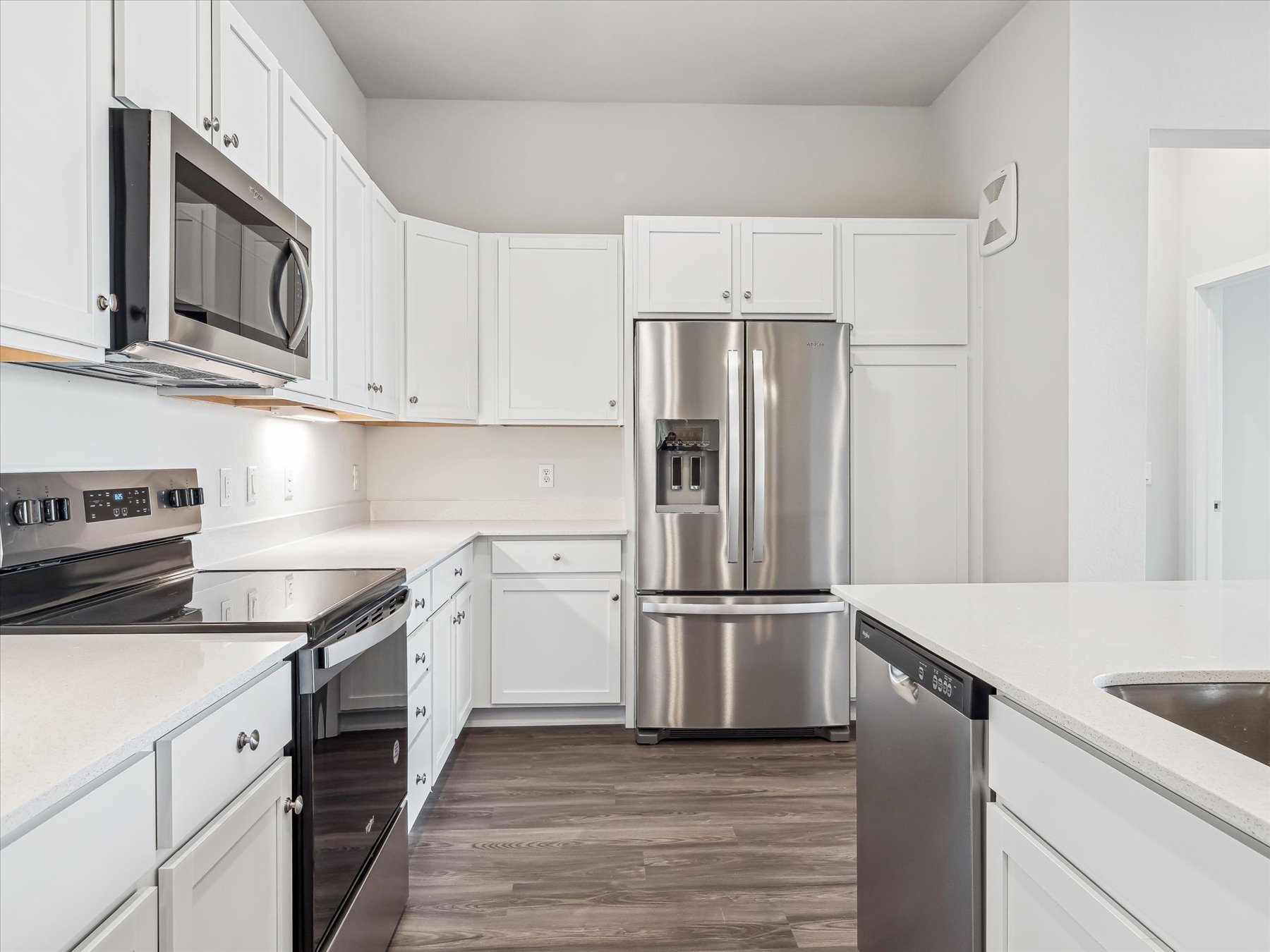 A kitchen with white cabinets.