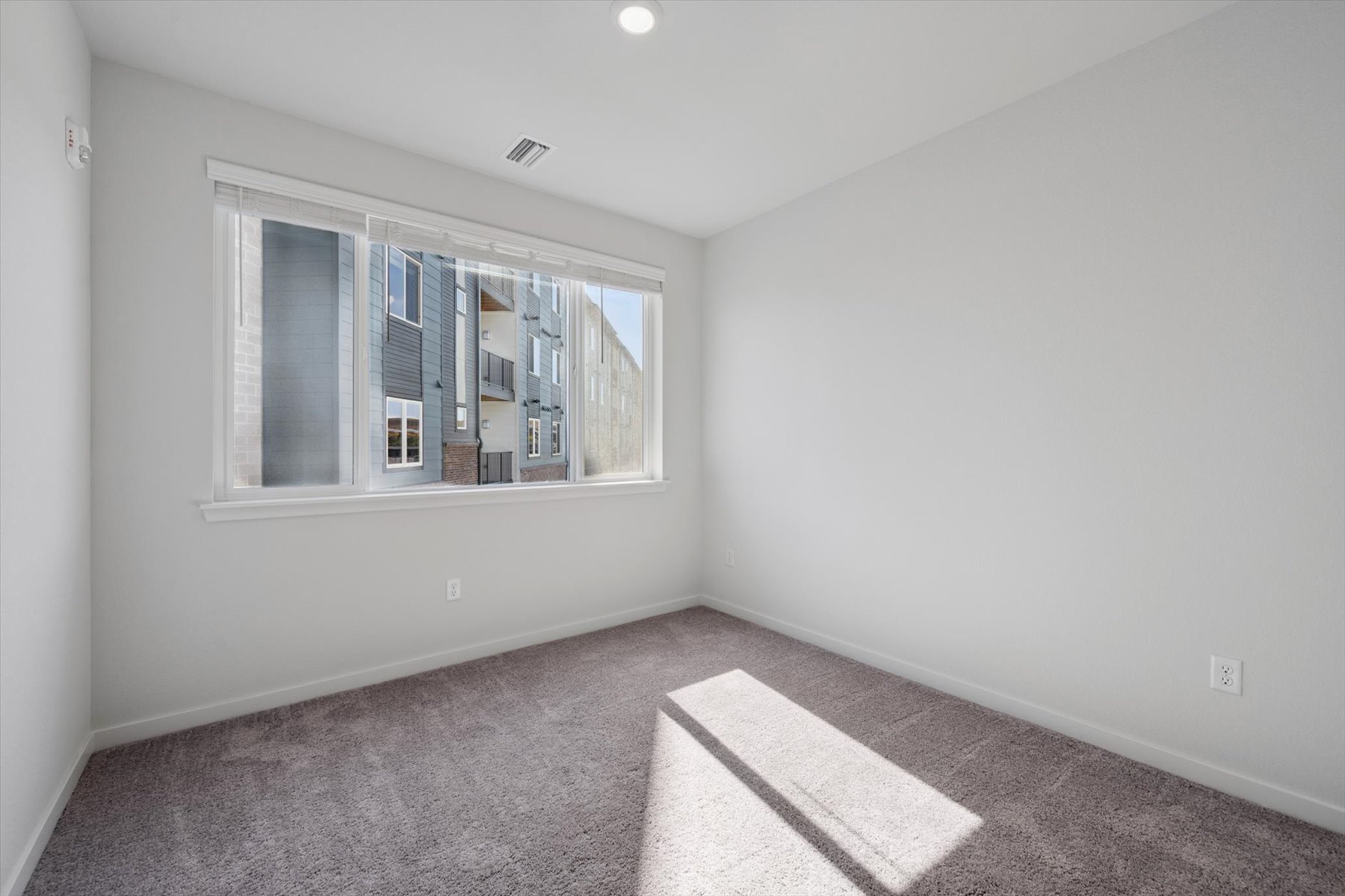 A room with a window and carpet.