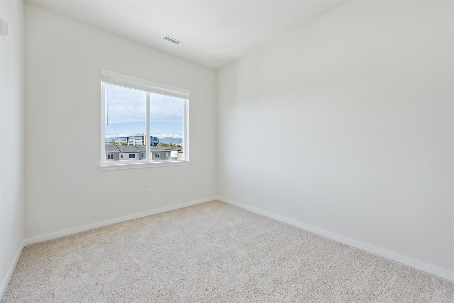 A room with a window and a carpet.