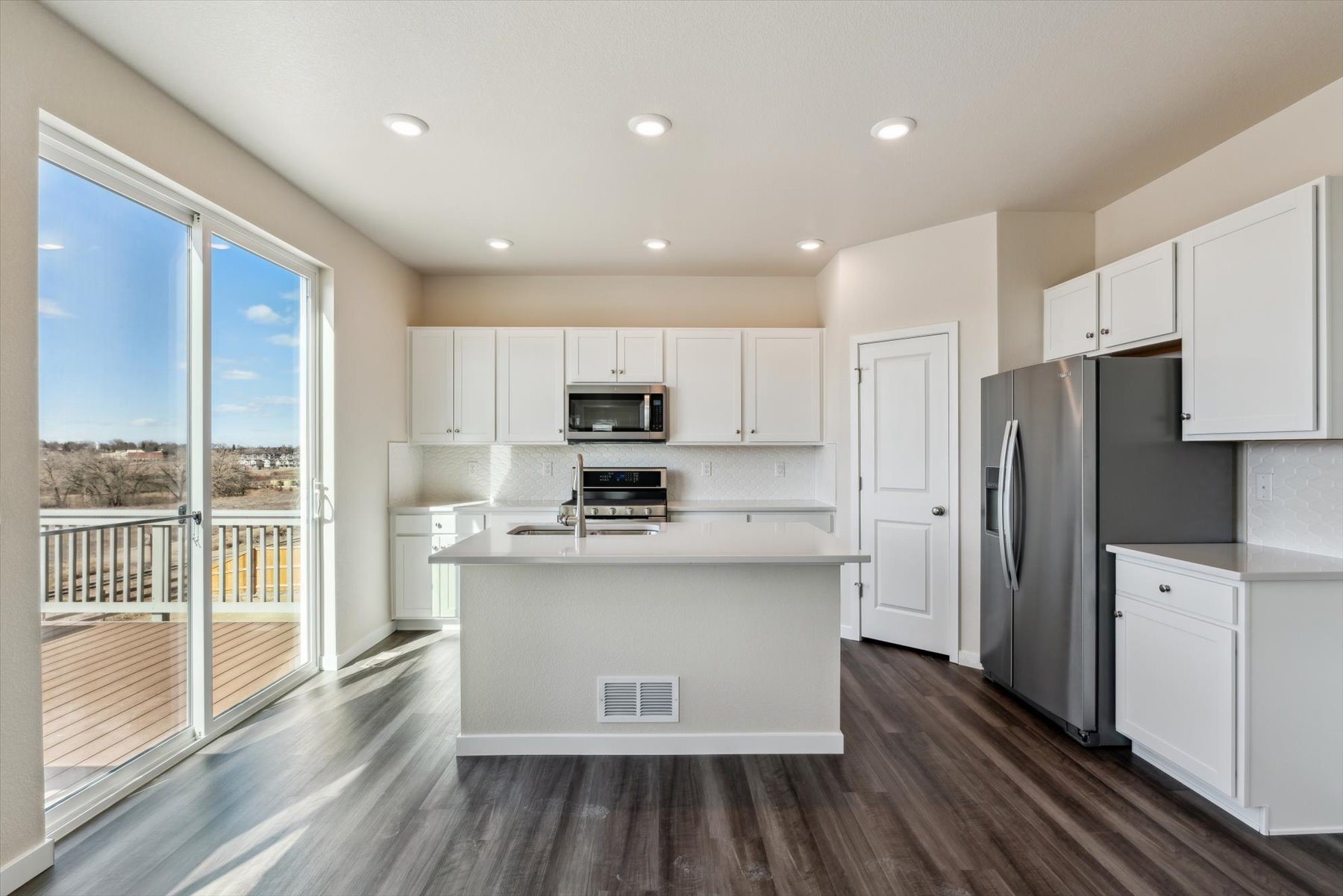 A kitchen with white cabinets.
