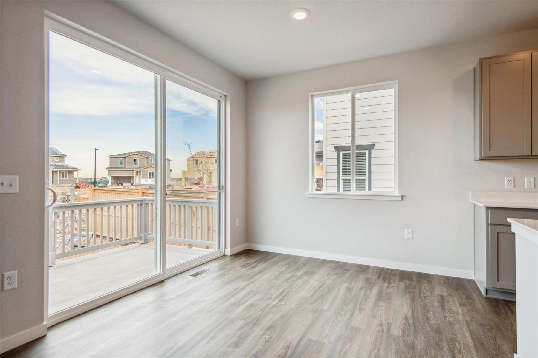 A room with a wood floor and a window with a view of a city.