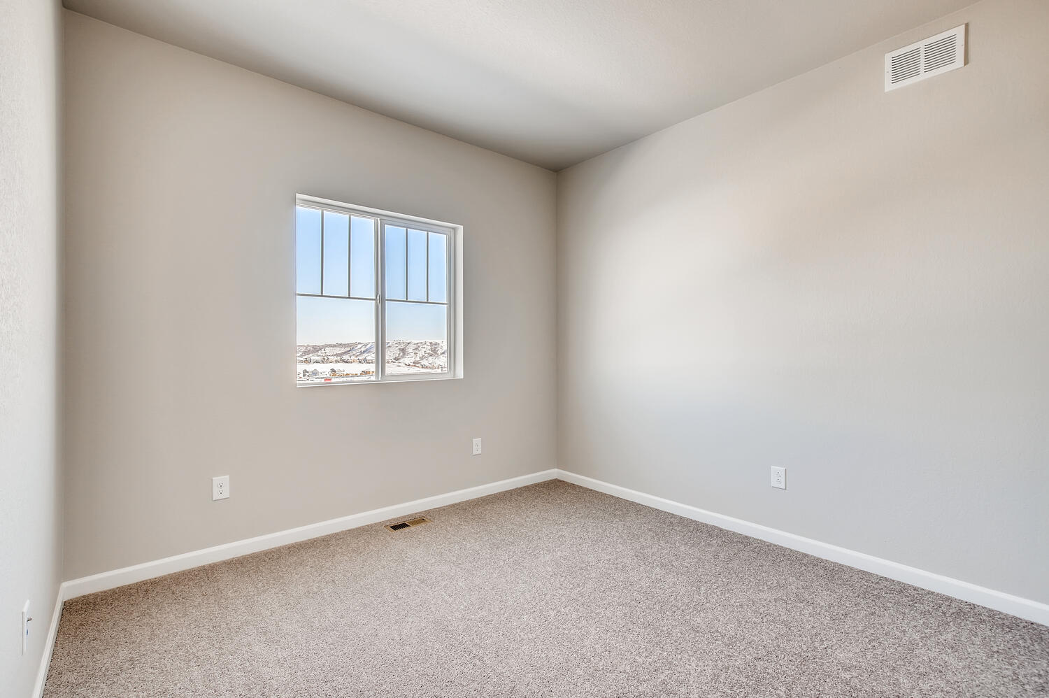 A room with a window and carpet.