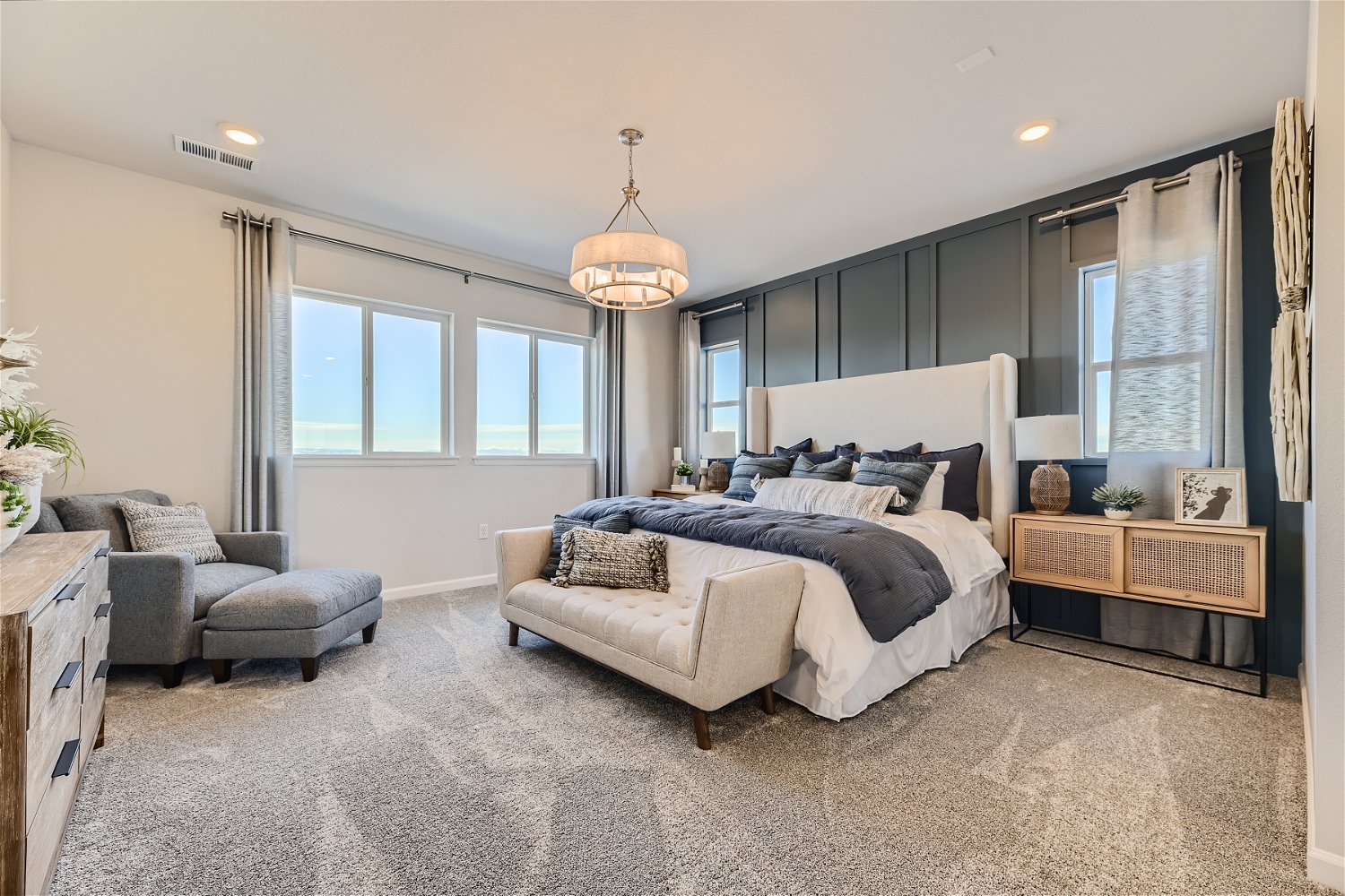 A bedroom with a bed and a chair.