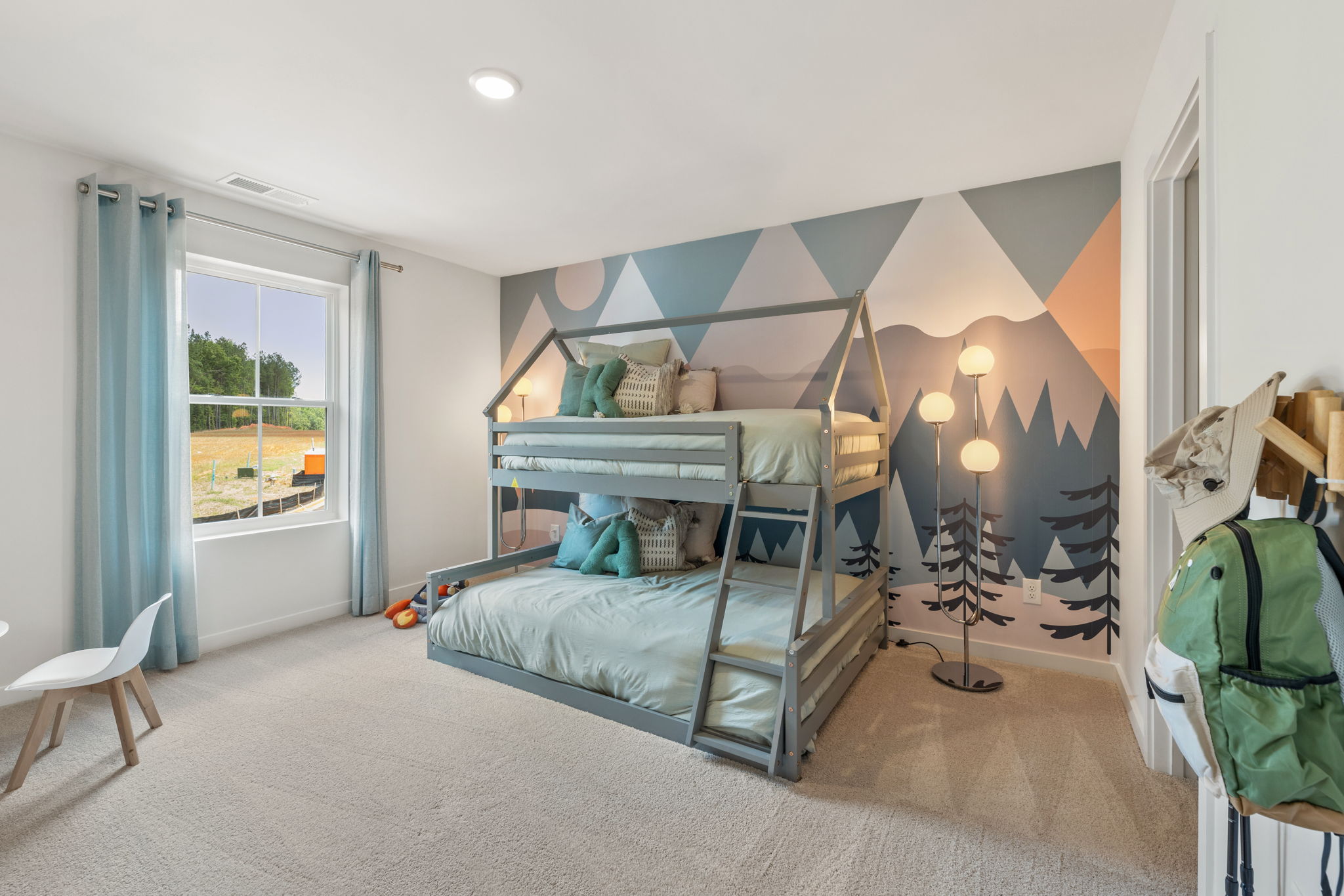 A bedroom with a bed and a chair.