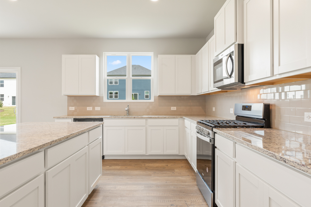 A kitchen with white cabinets.