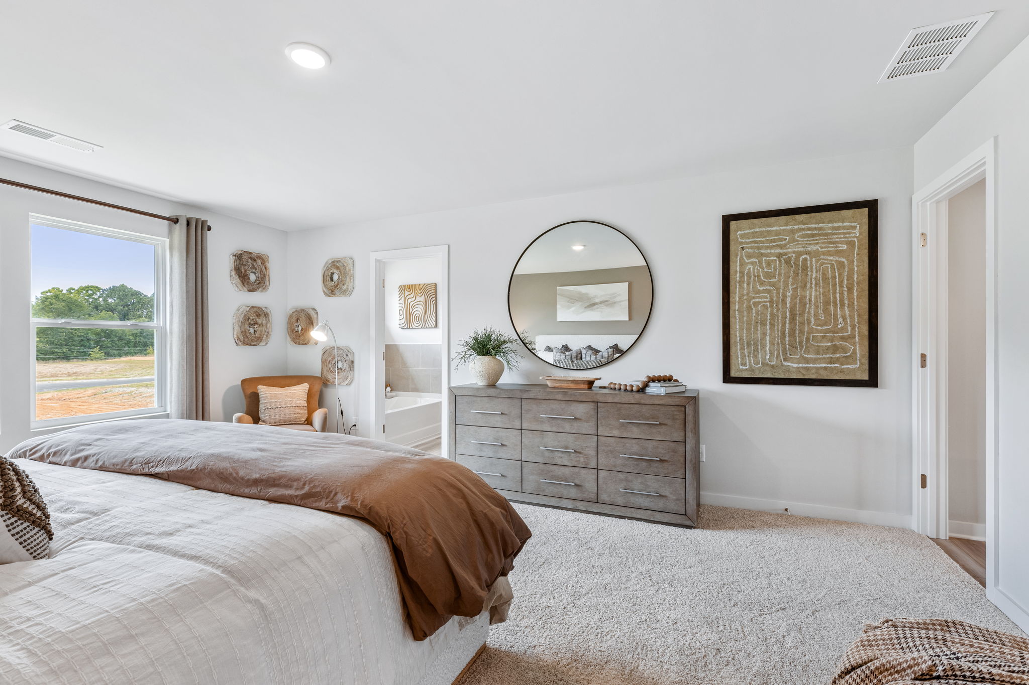 A bedroom with a bed and a mirror.