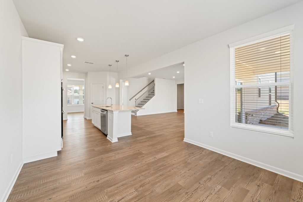A large empty room with a wood floor and a wood floor.
