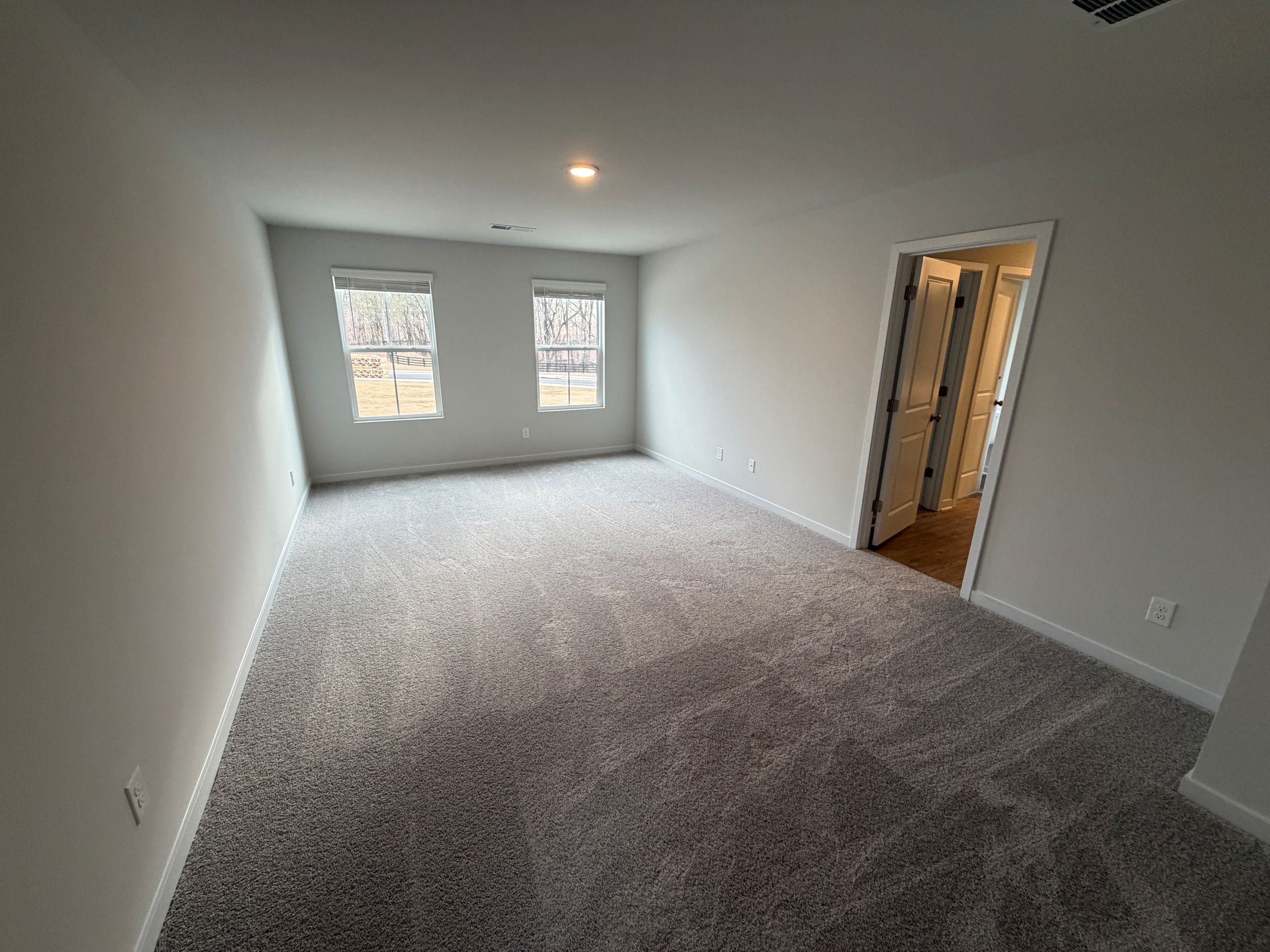 A room with a carpet and a door.