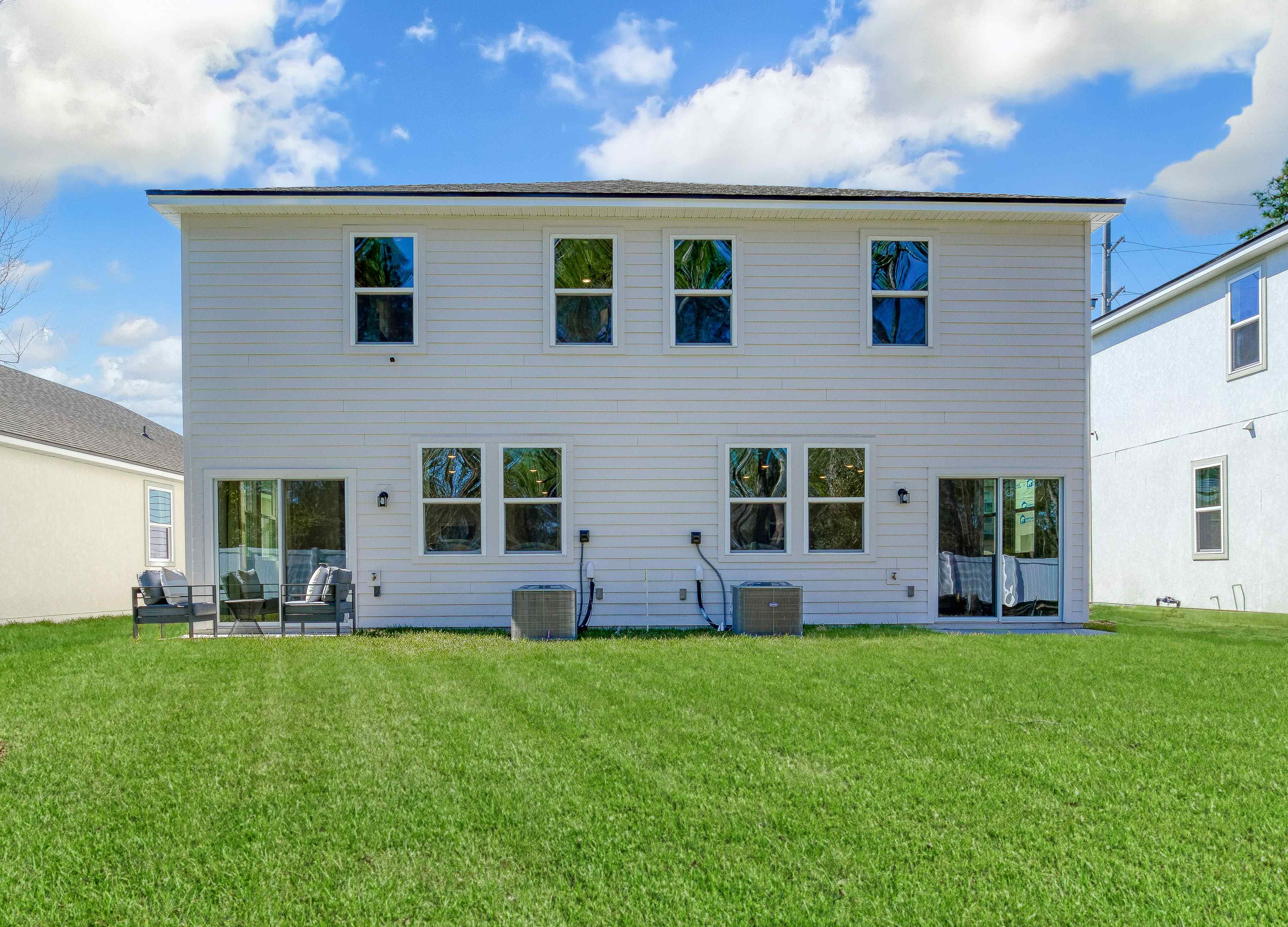 A white house with a green lawn.