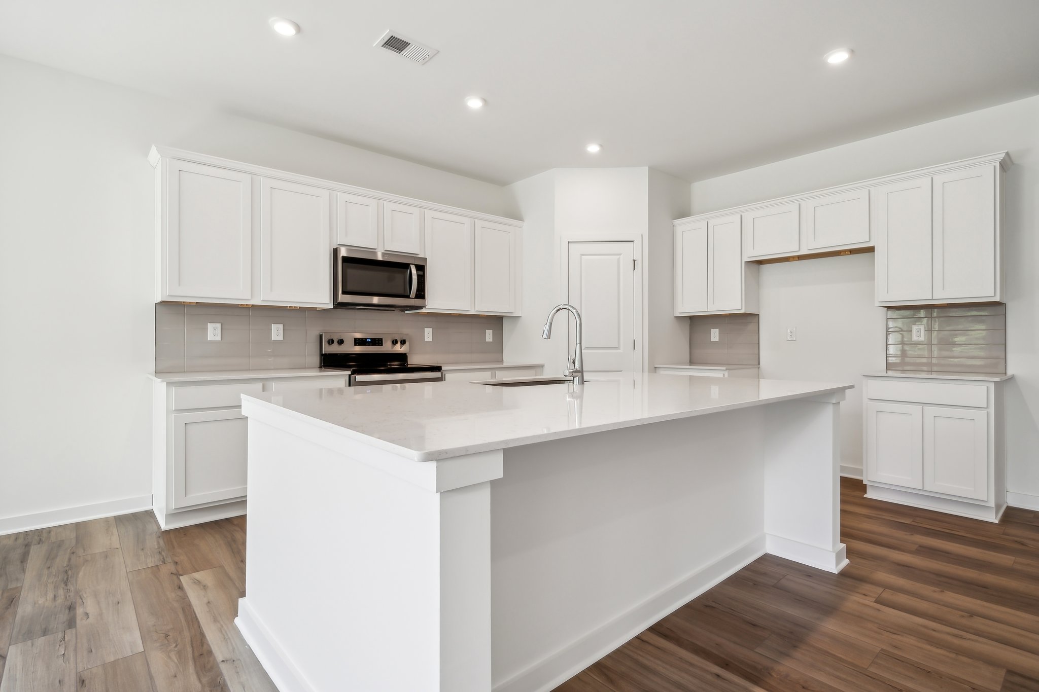 A kitchen with white cabinets.