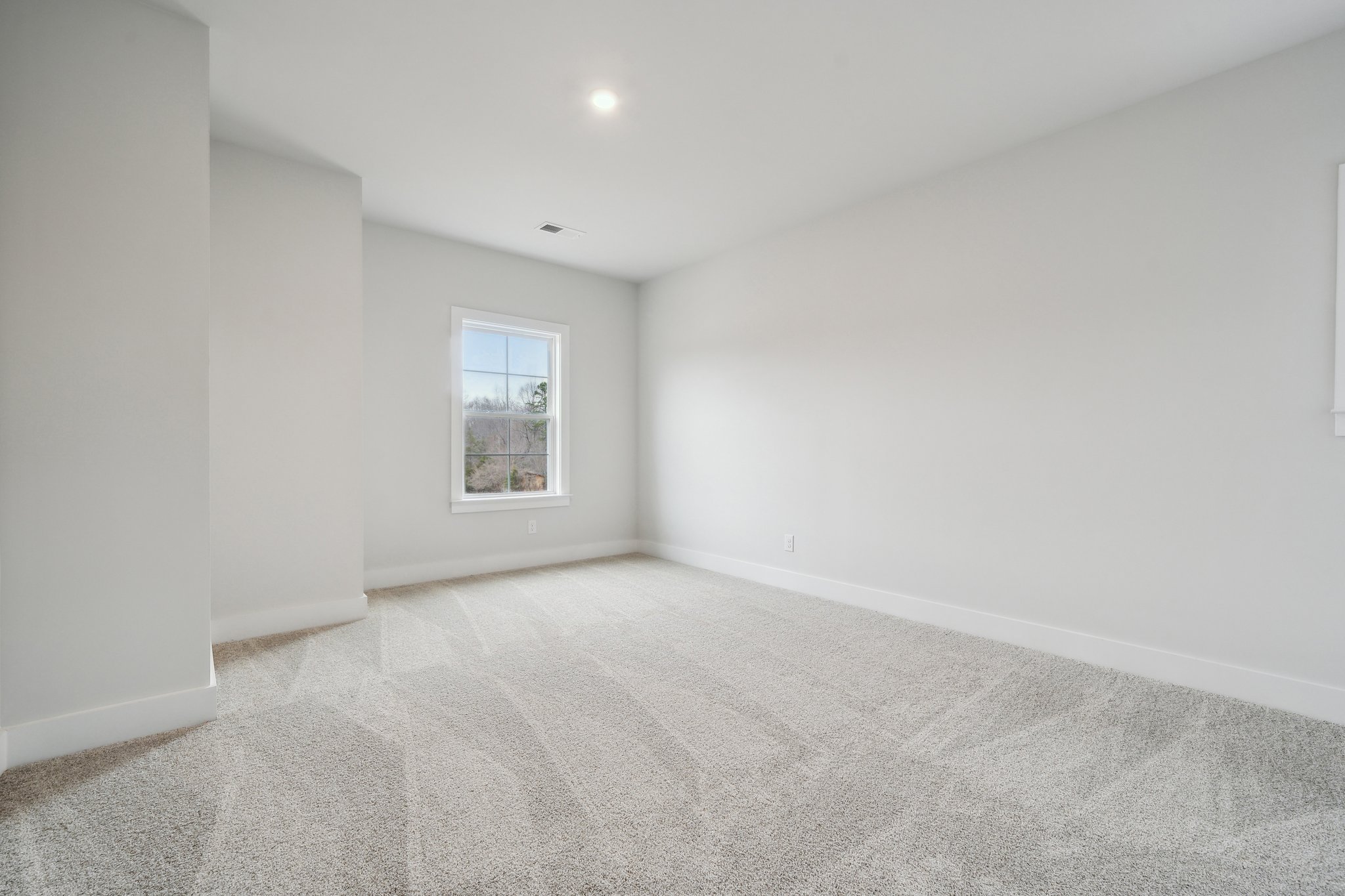 A room with a carpet and a window.