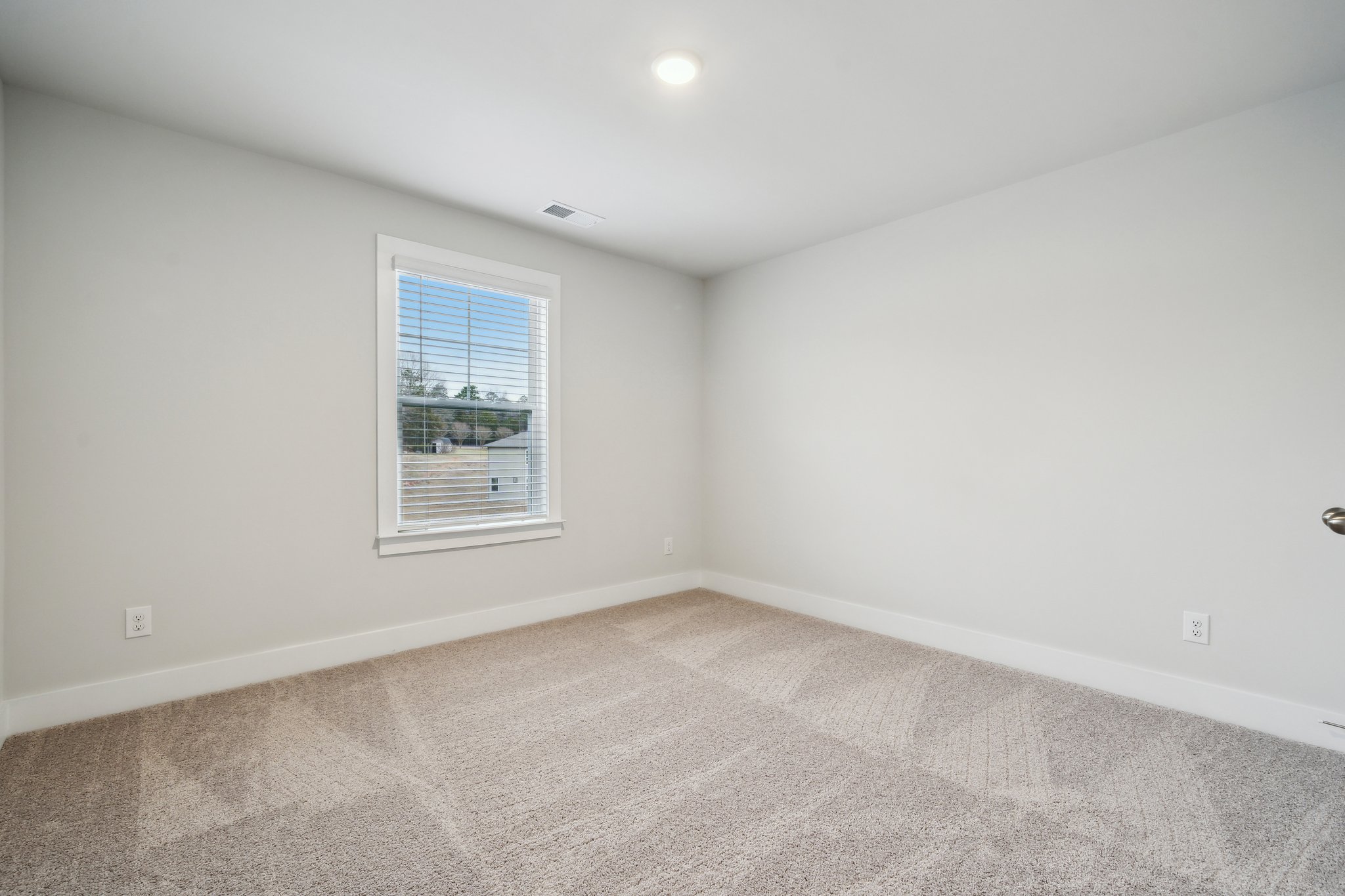 A room with a window and a carpet.