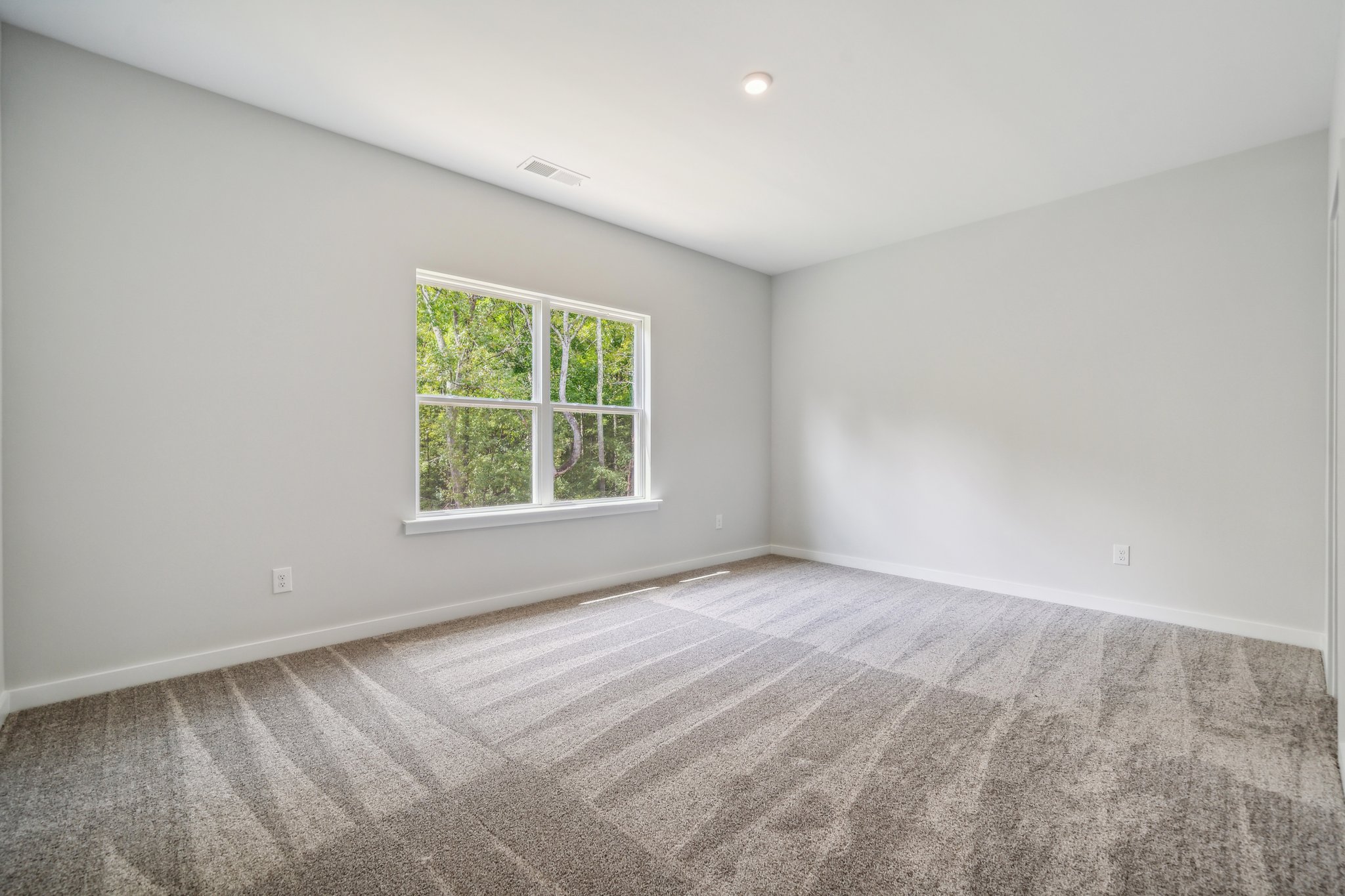 A room with a window and carpet.
