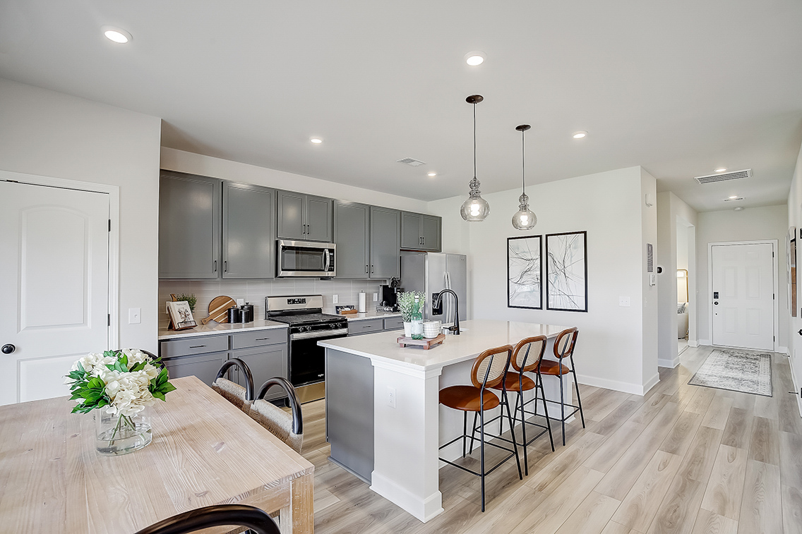 A kitchen with a dining table and white cabinets.