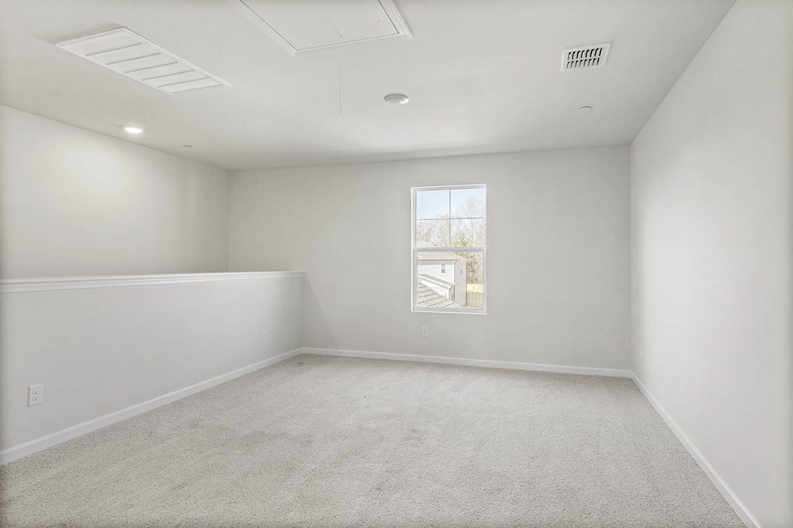 A room with a white wall and a painting on the wall.