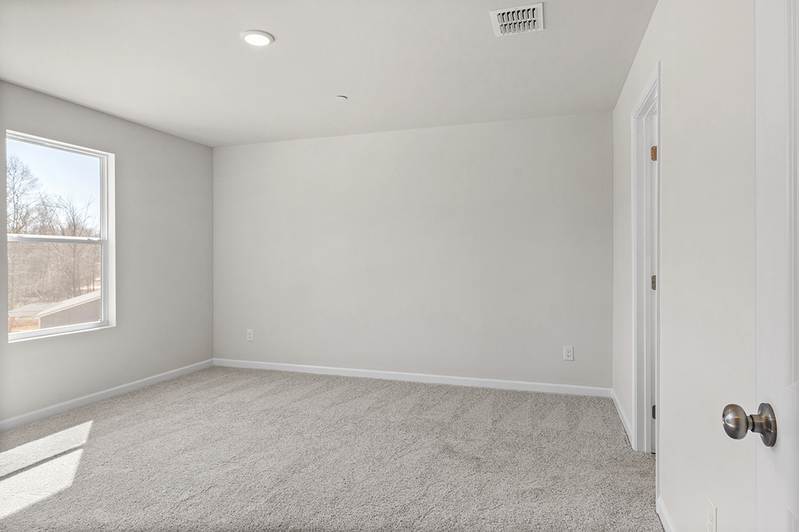 A room with a carpet and a window.