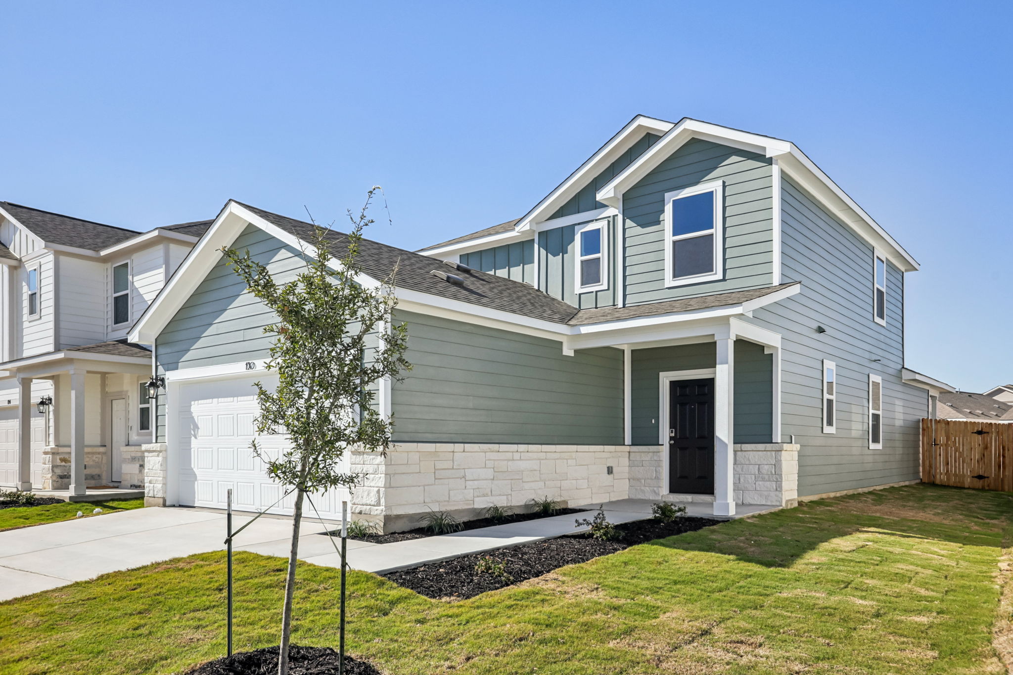 A house with a tree in the front yard.