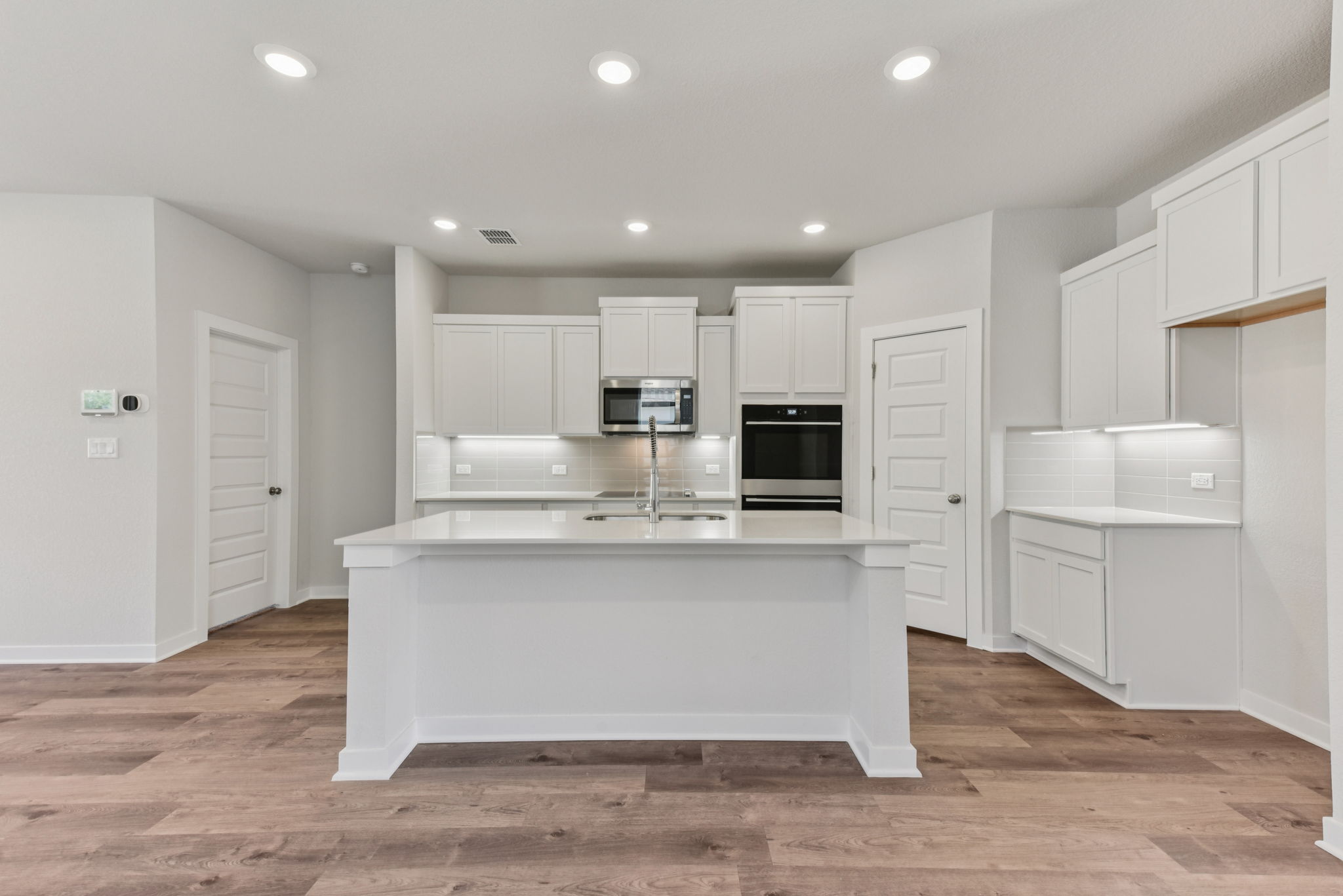 A kitchen with white cabinets.