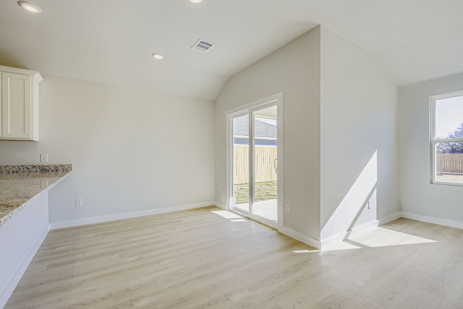 A room with a wood floor and a white staircase.