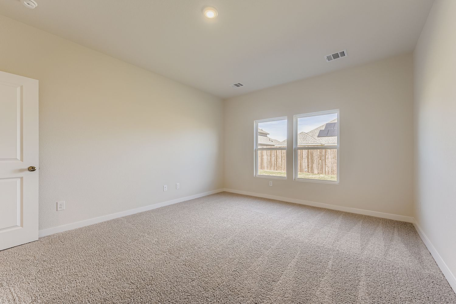 A room with a carpet and a window.