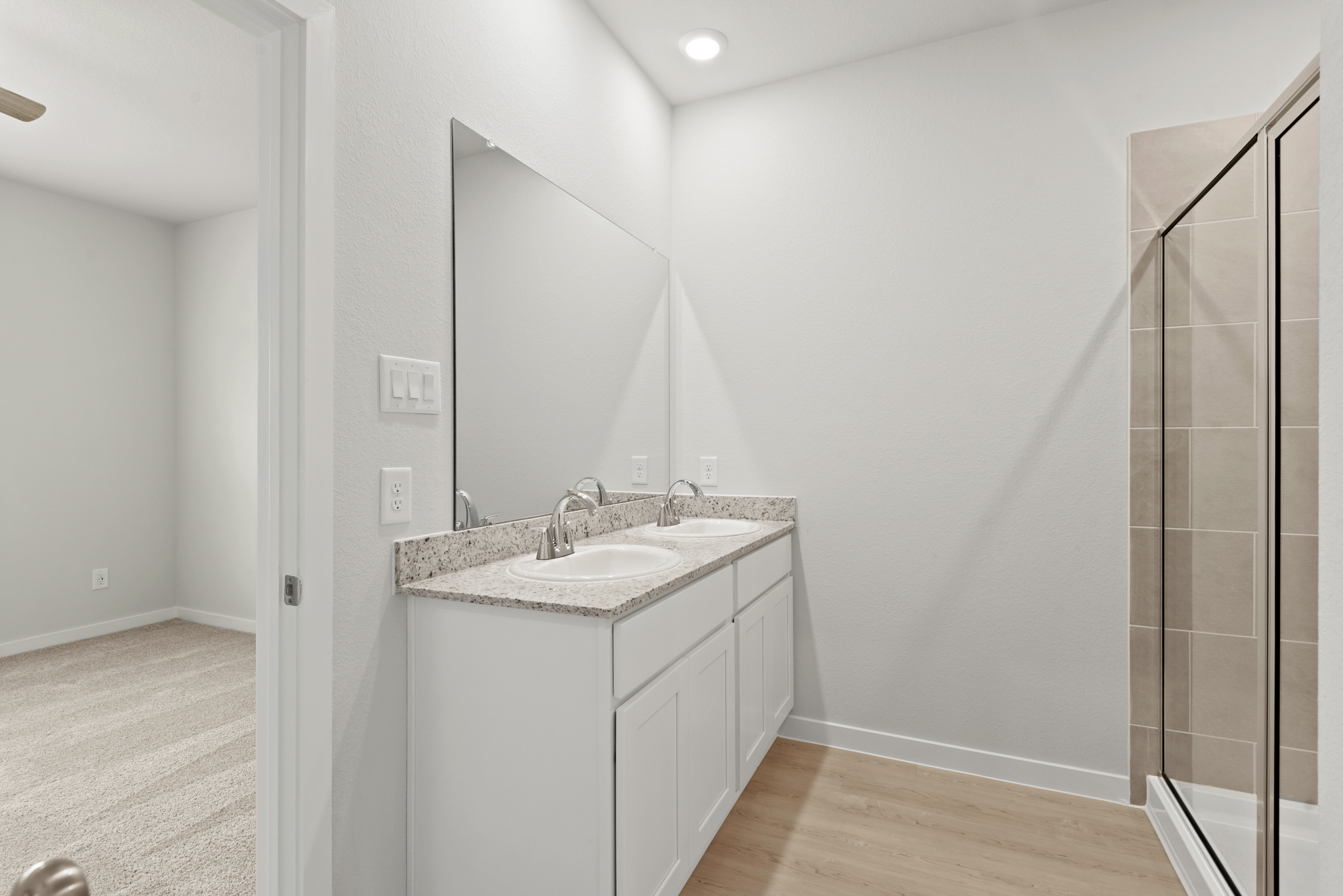 A bathroom with a sink and a shower unit.