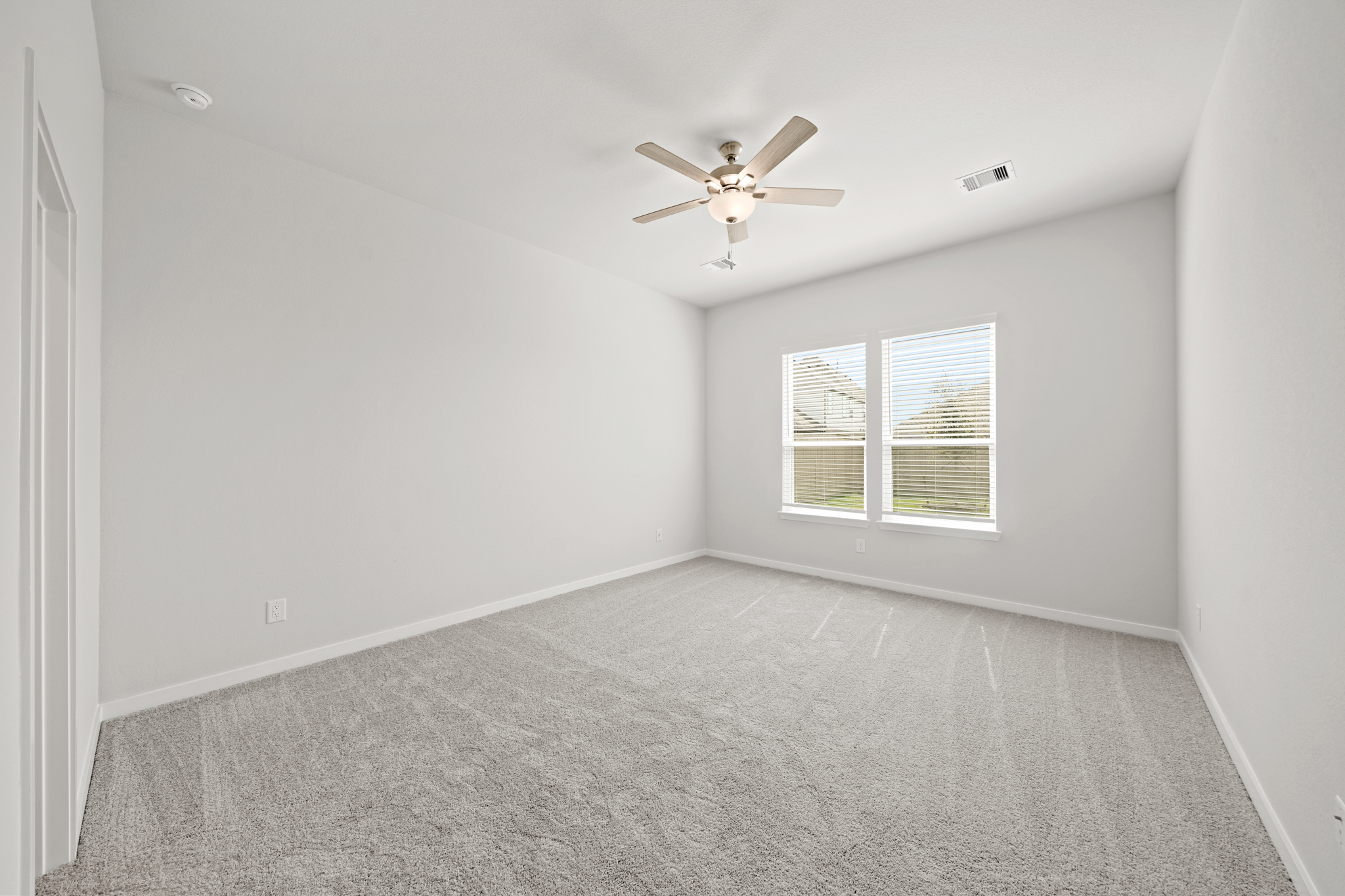 A room with a ceiling fan and a window.