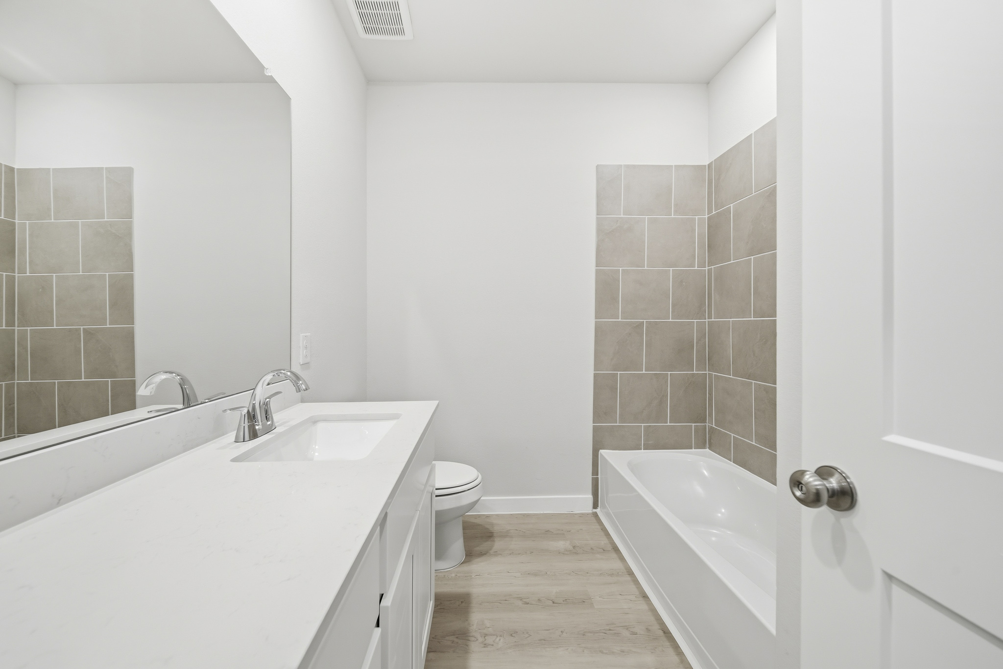 A bathroom with a tub sink and toilet.