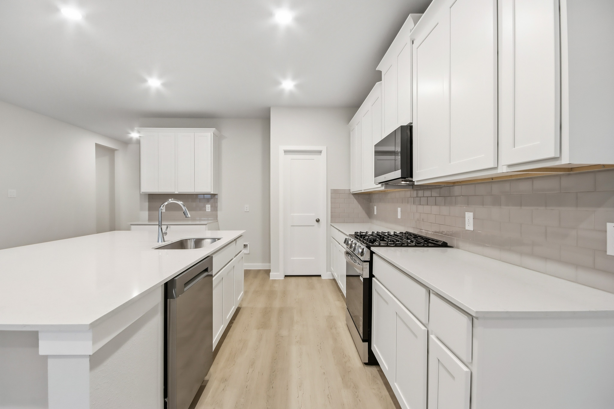 A kitchen with white cabinets.