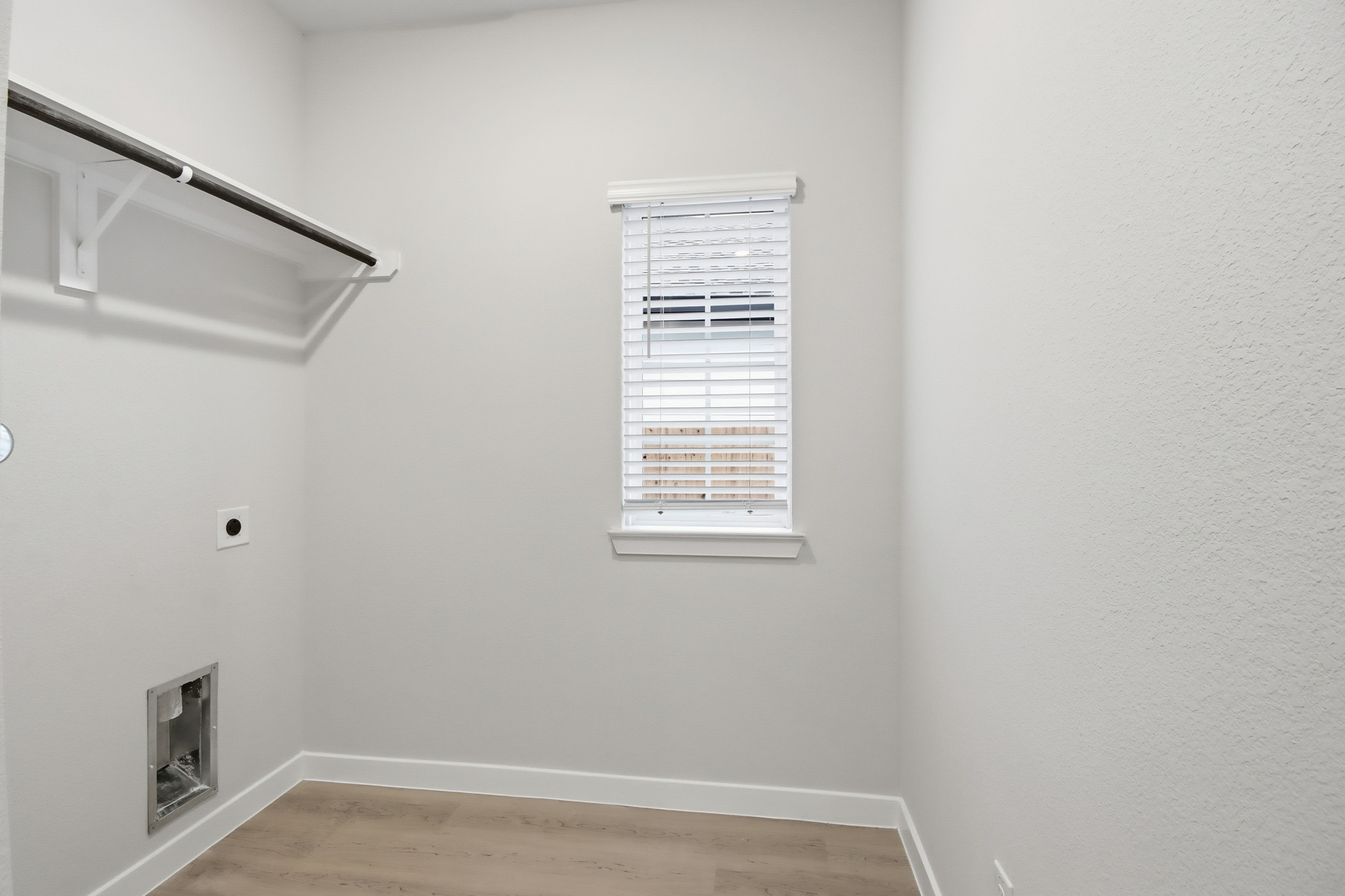 A room with a window and a wood floor.