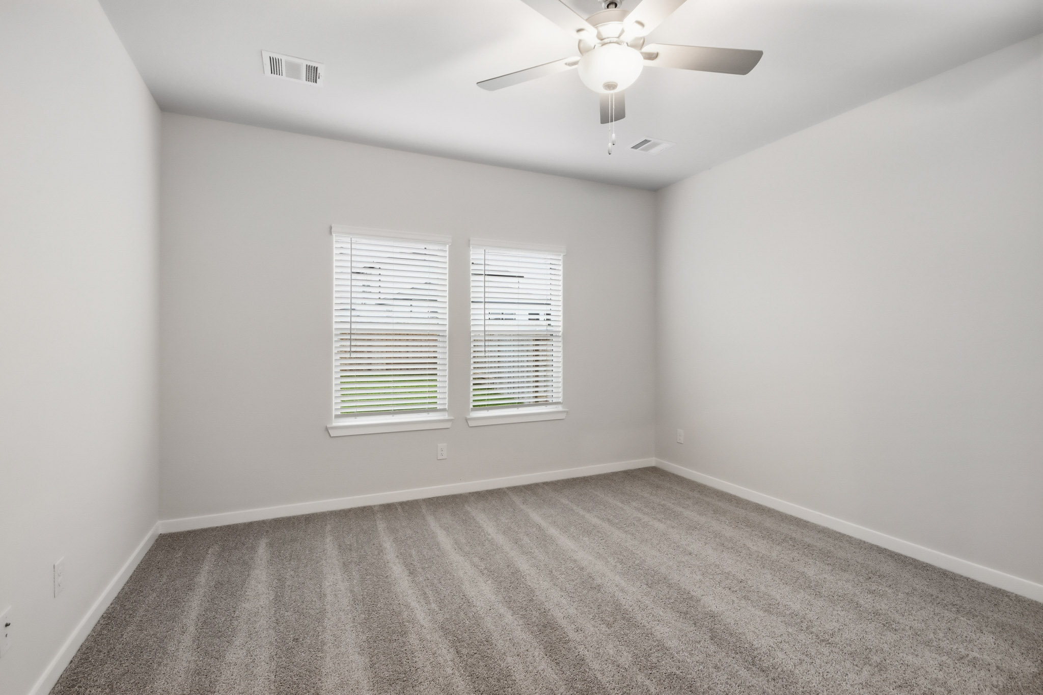 A room with a ceiling fan and a window.