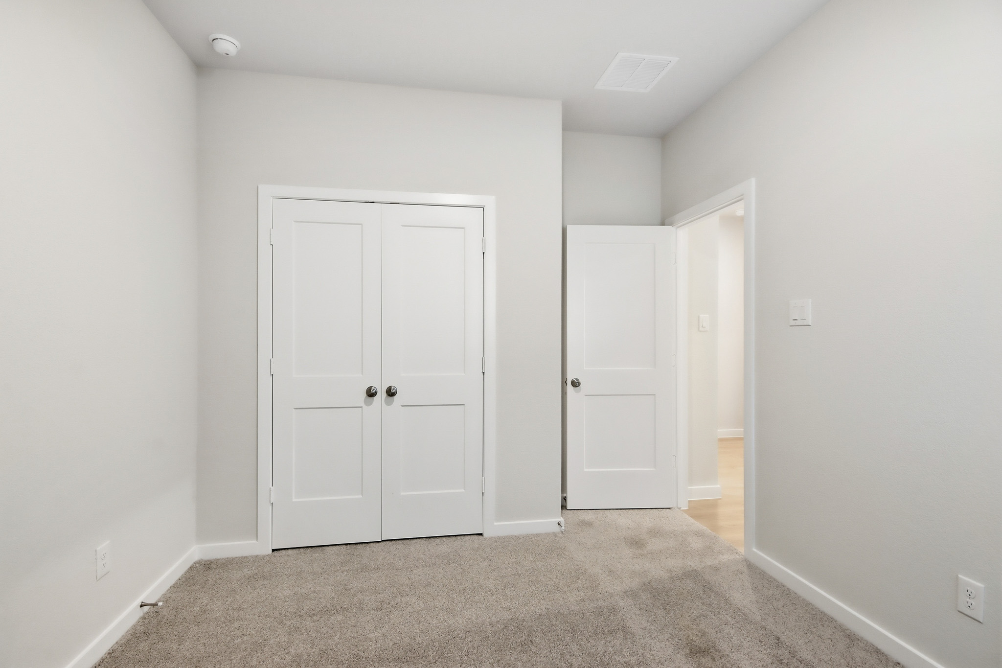A hallway with white doors.