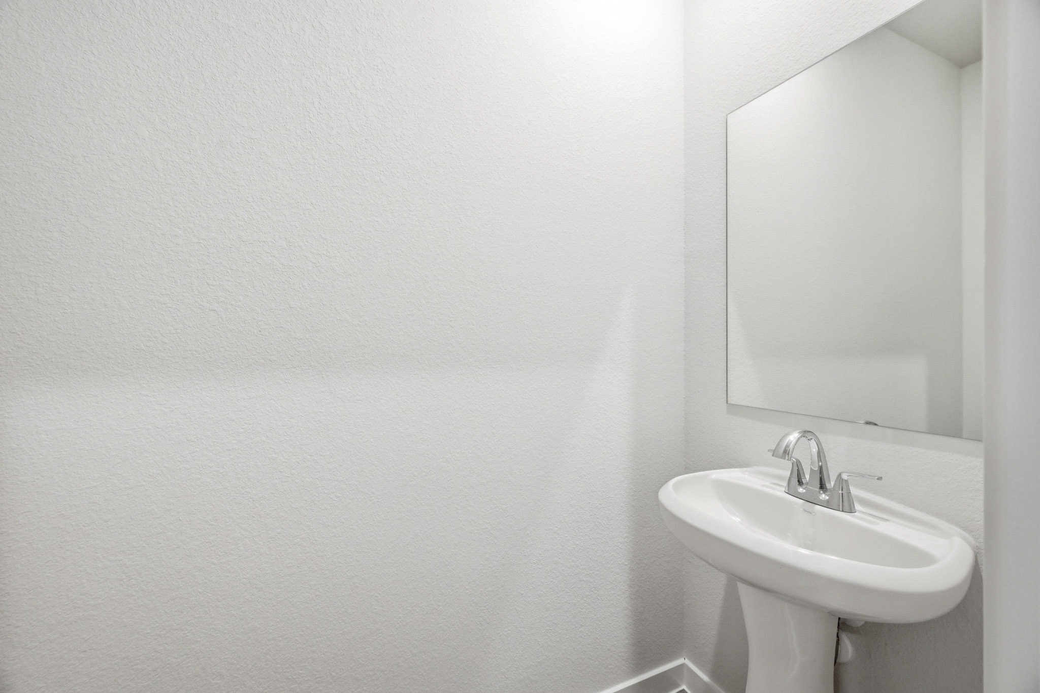 A bathroom with a mirror and sink.